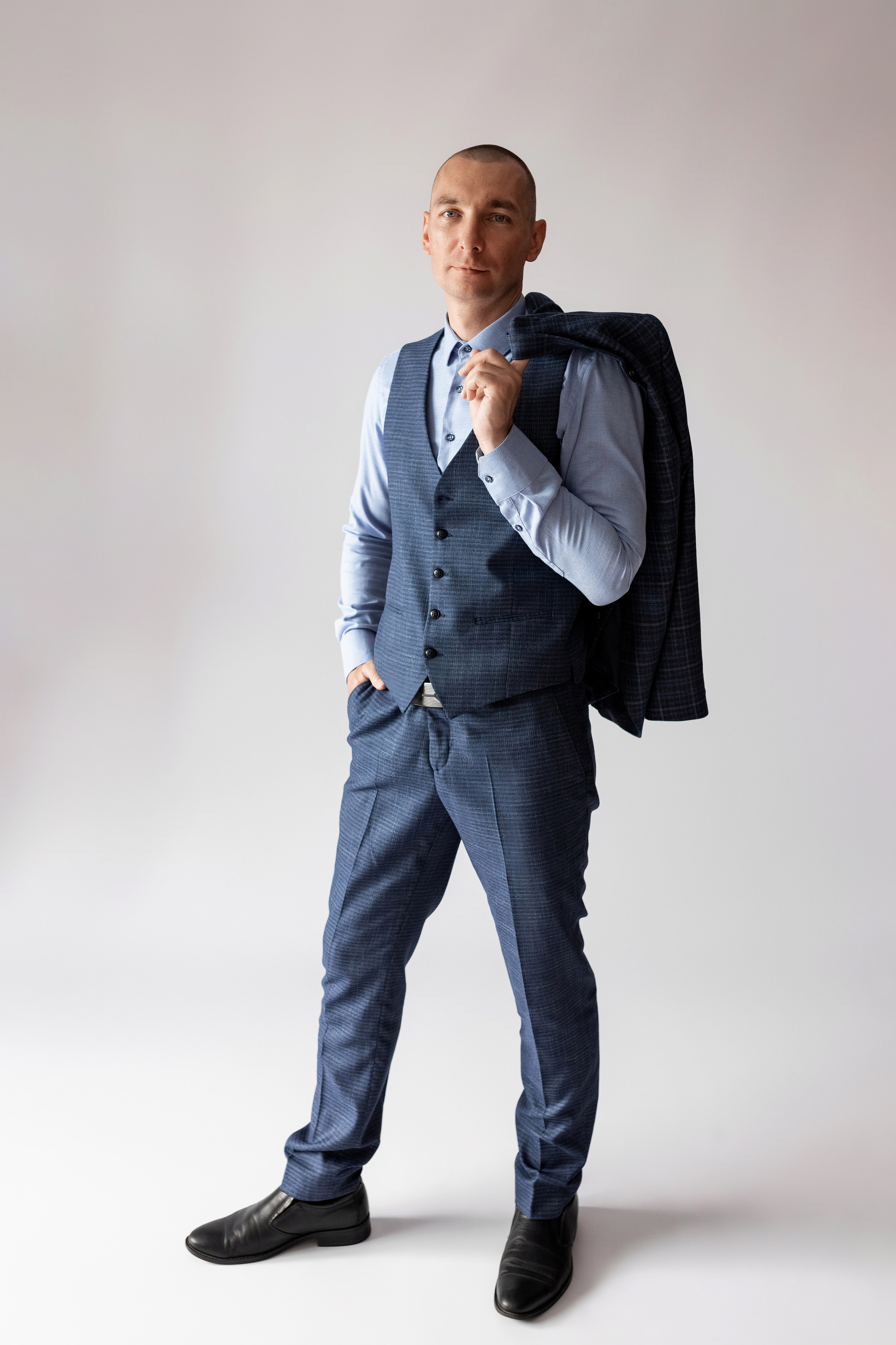 Индивидуальная мужская фотосессия в студии минимализм. на стуле. на белом фоне, на бежевом фоне. В классическом костюме тройка