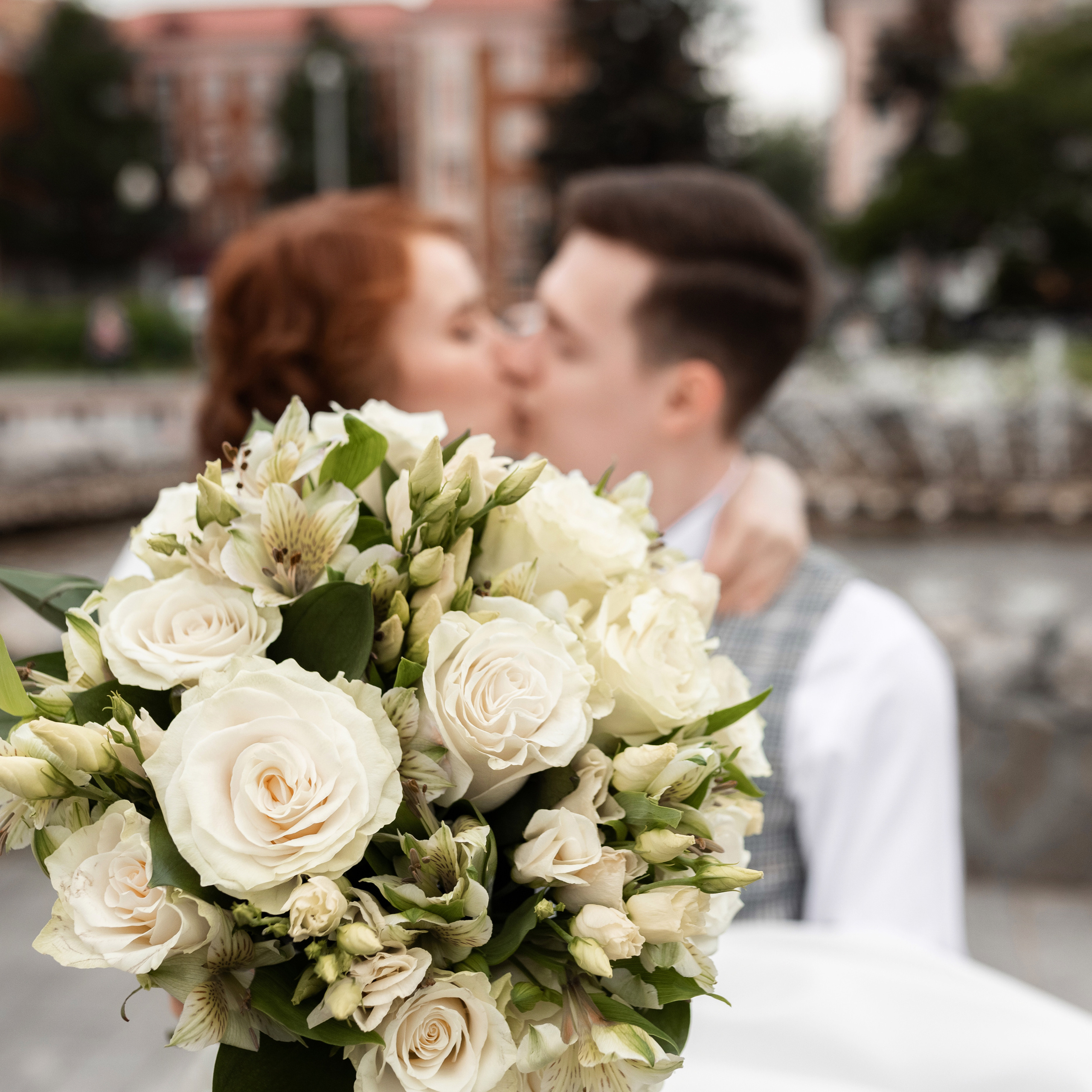 Невеста и жених кружатся в брызгах фонтана с букетом