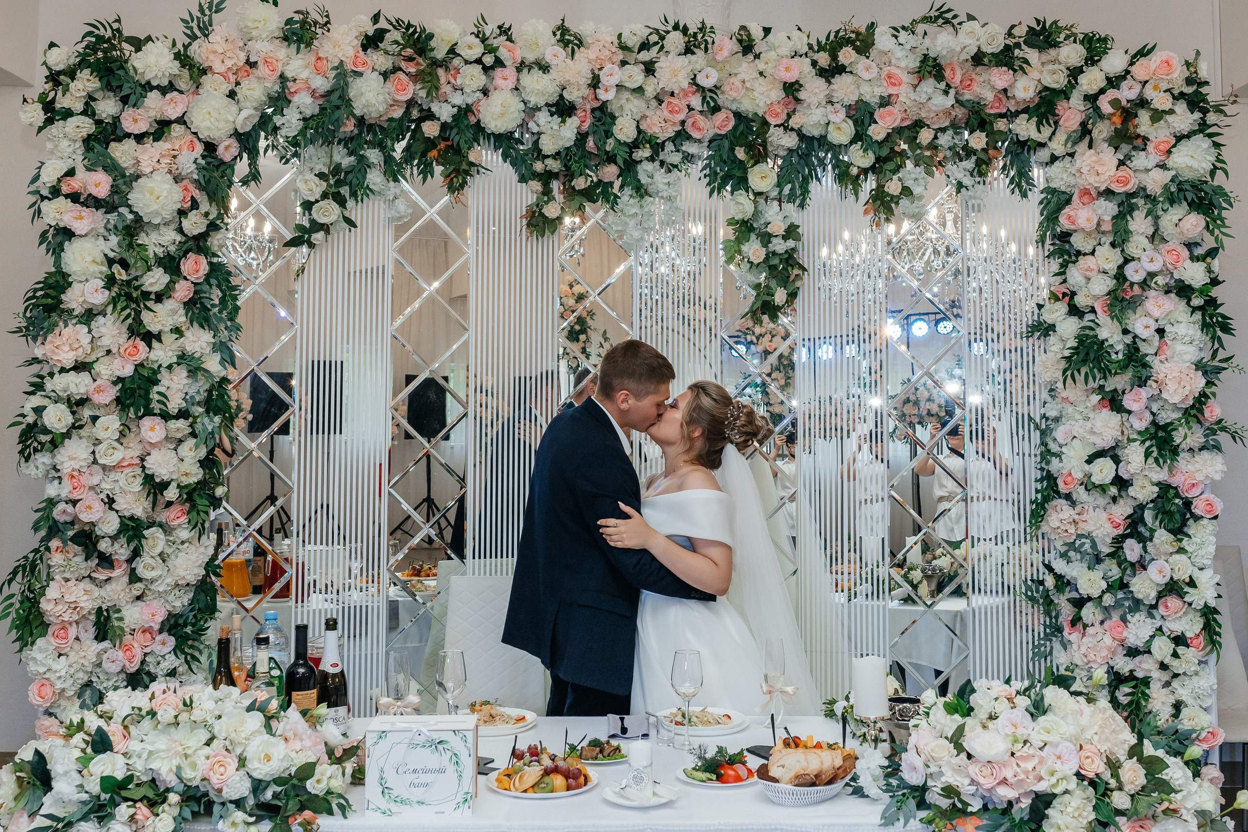 Жених и невеста за столом целуются