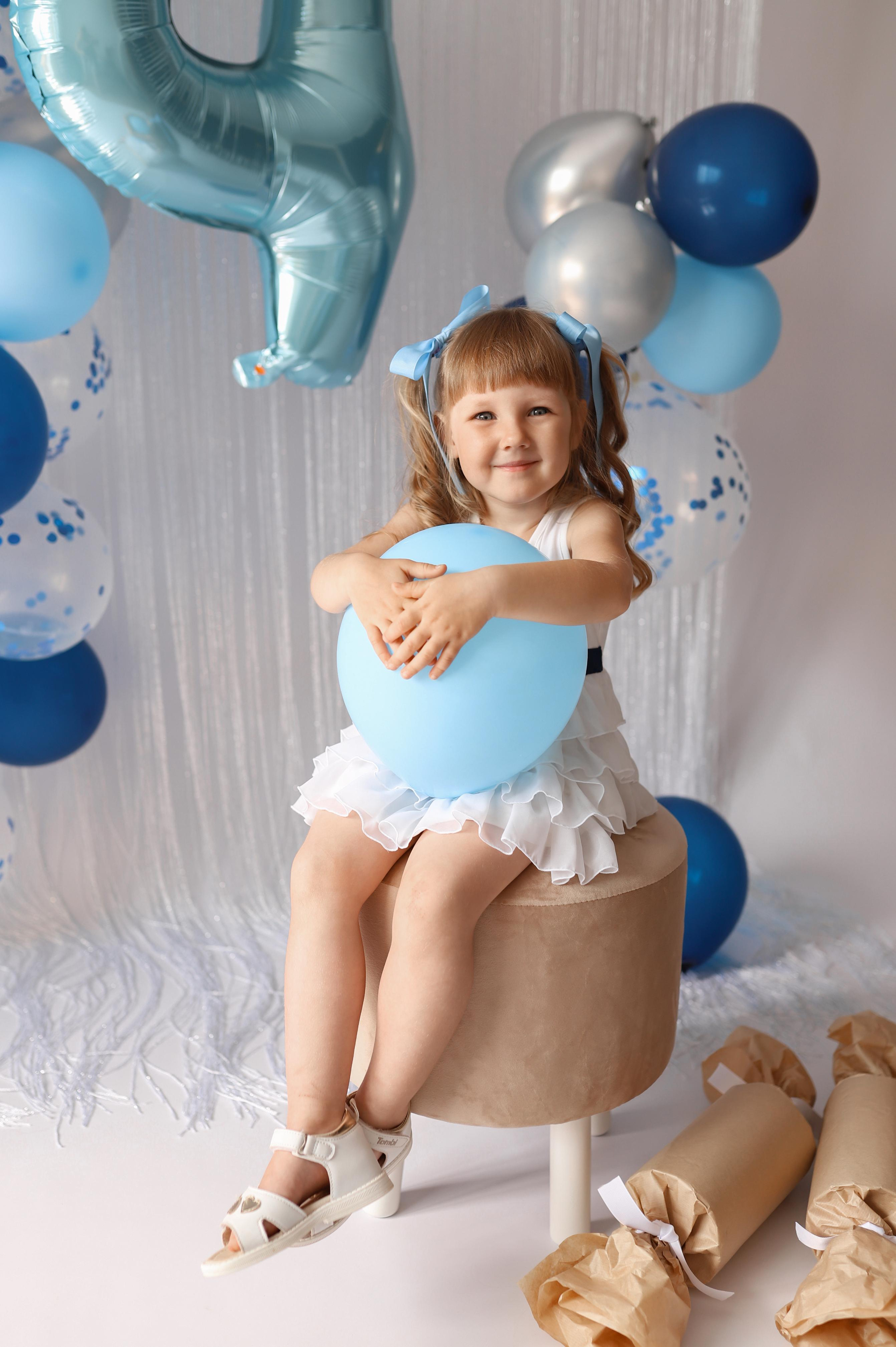 фотосессия на день рождения дочке с шариками тортом в белом платье с большими конфетами и большой ложкой