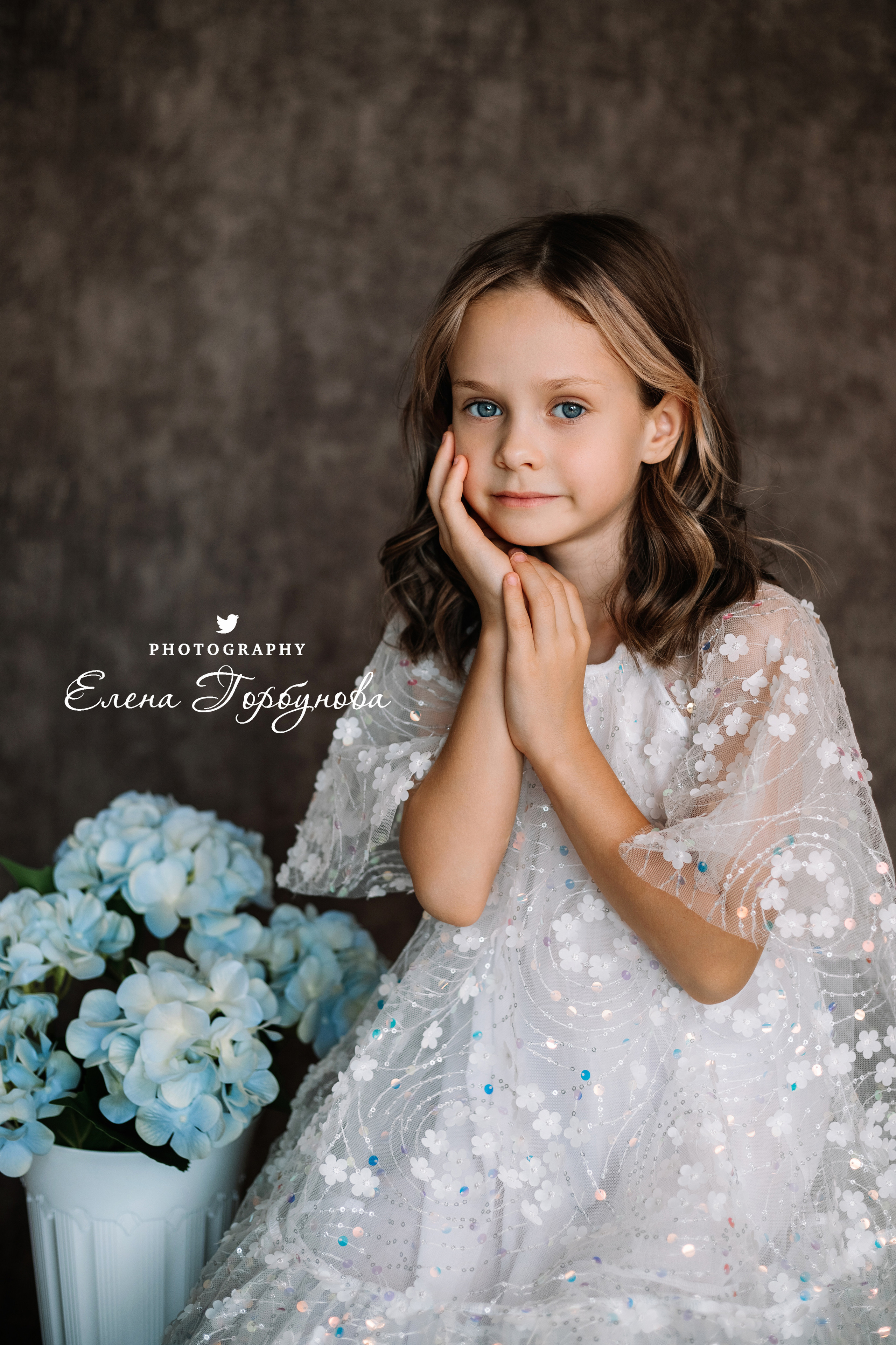 Фотосессия в садике Пермь фотограф Елена Гобунова Девочка в белом платье позирует на стуле с цветами Открытка для мамы. Детская фотосессия. Детский портрет в студии