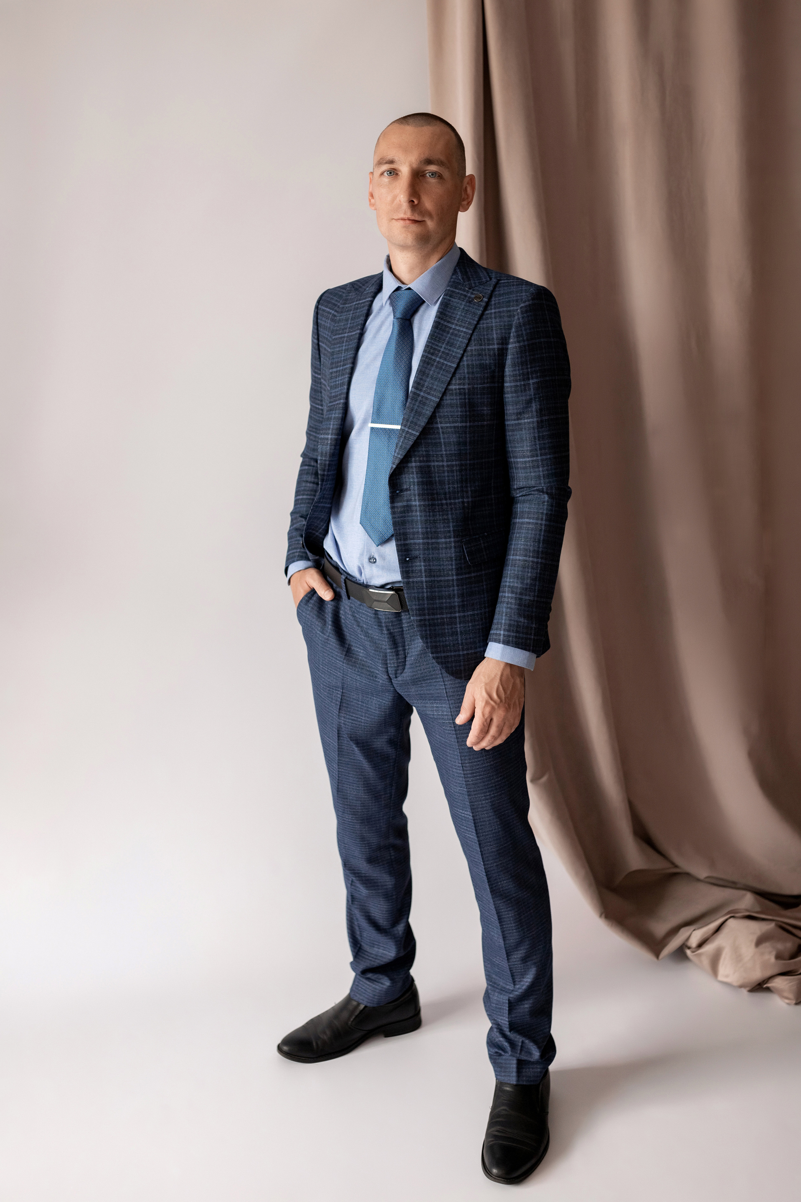 Индивидуальная мужская фотосессия в студии минимализм. на стуле. на белом фоне, на бежевом фоне. В классическом костюме тройка