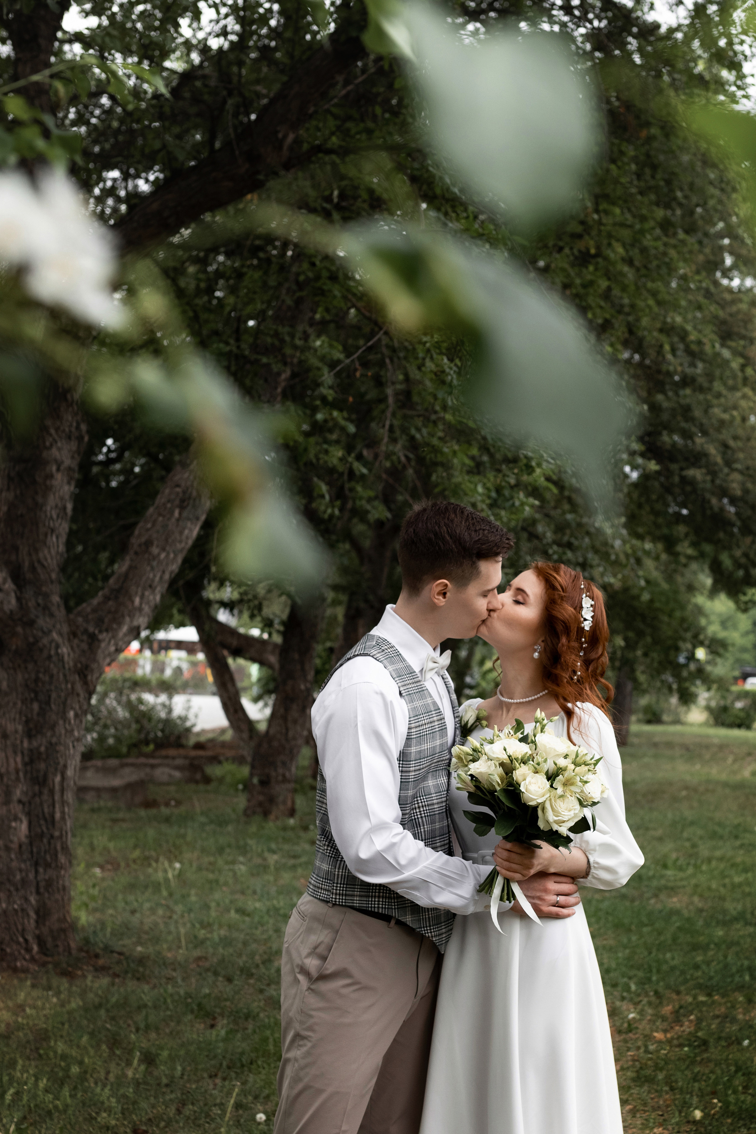 жених и невеста бегут по яблоневой аллее