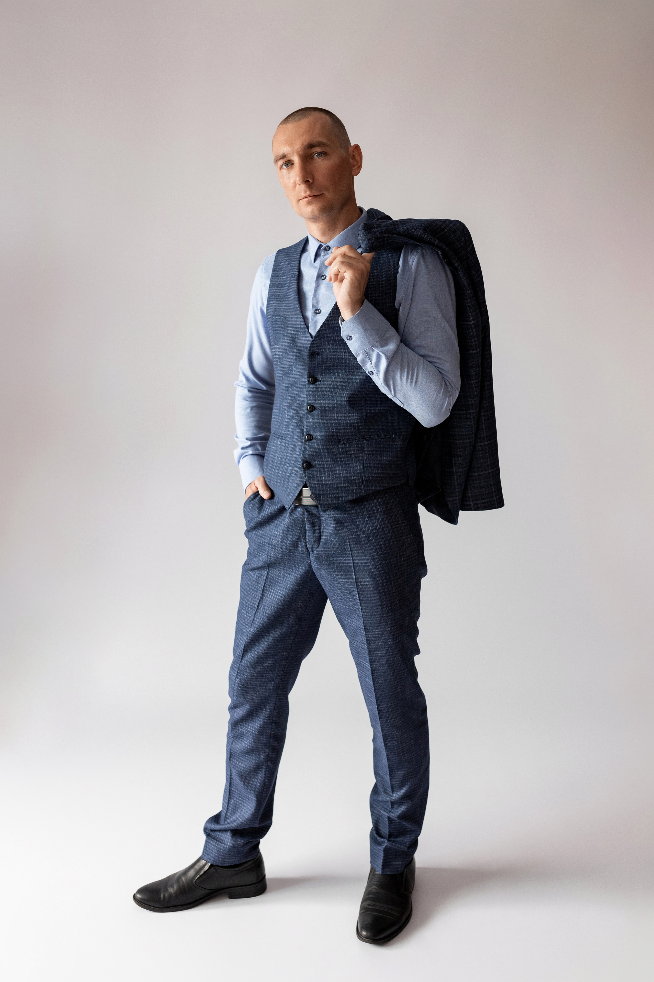 Индивидуальная мужская фотосессия в студии минимализм. на стуле. на белом фоне, на бежевом фоне. В классическом костюме тройка