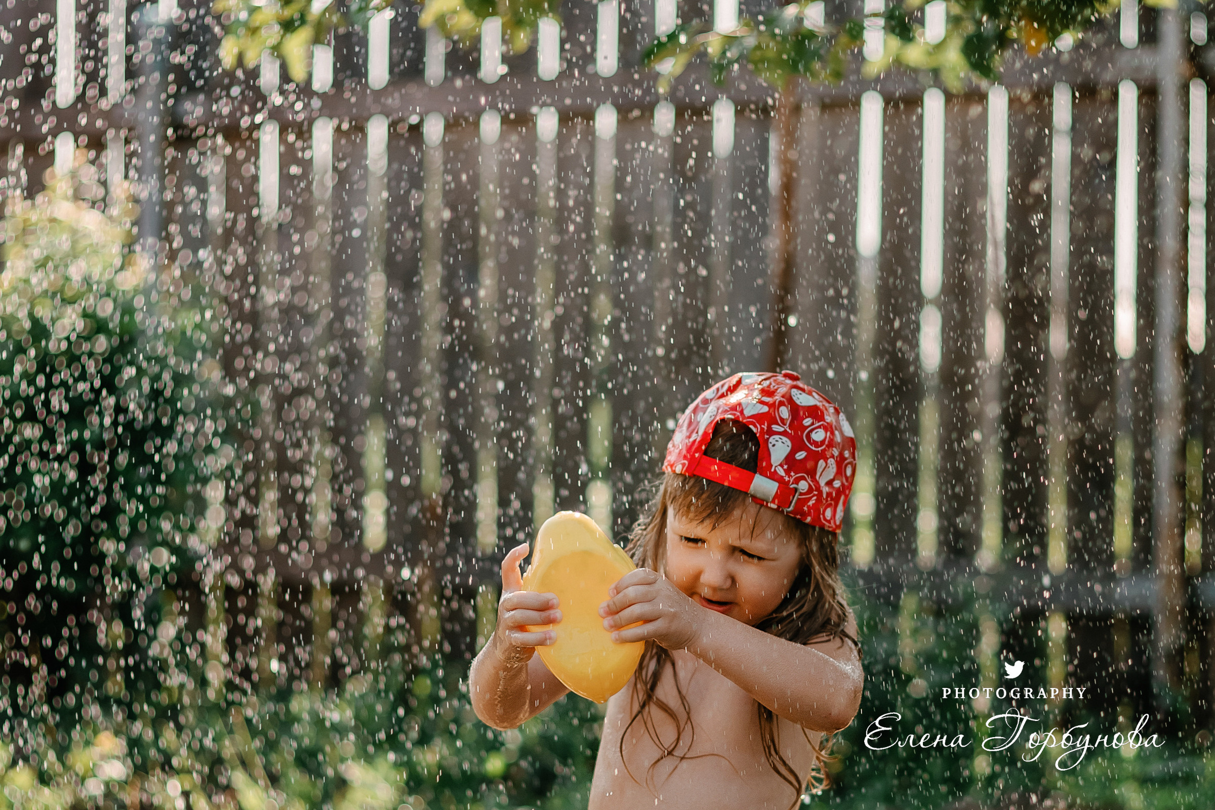 Детская фотосессия на природе на даче летом в тазике под яблоней с брызгами воды, с фонтаном с уточкой