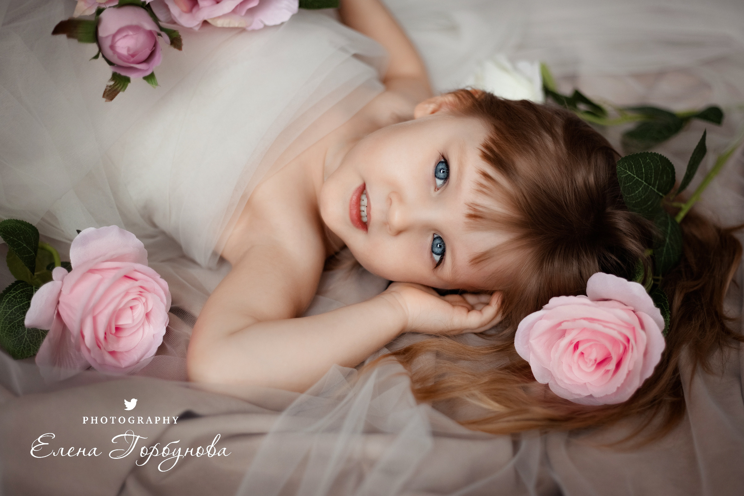 Девочка лежит в студии в фатине с розами с цветами. фотосессия детская