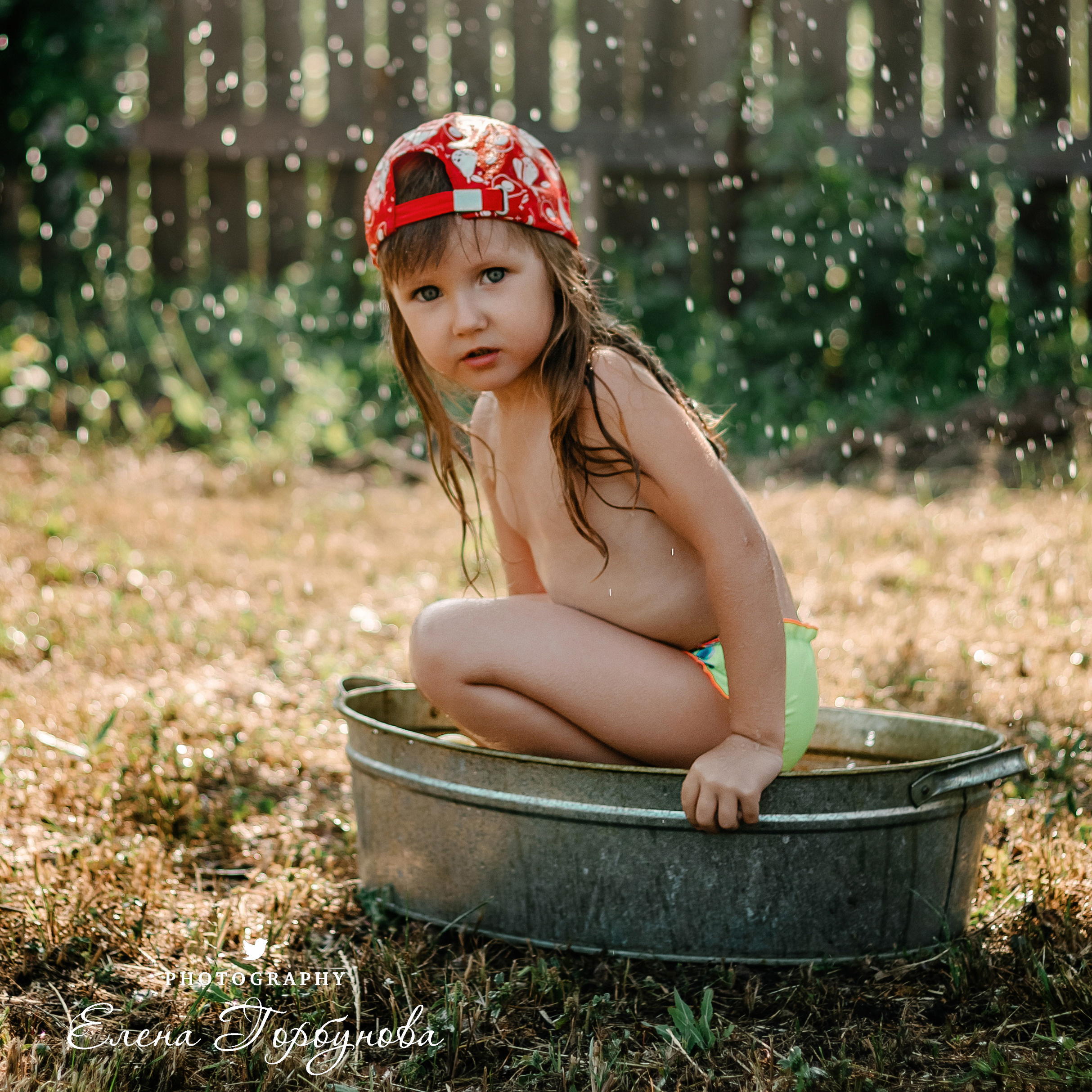 Детская фотосессия на природе на даче летом в тазике под яблоней с брызгами воды, с фонтаном