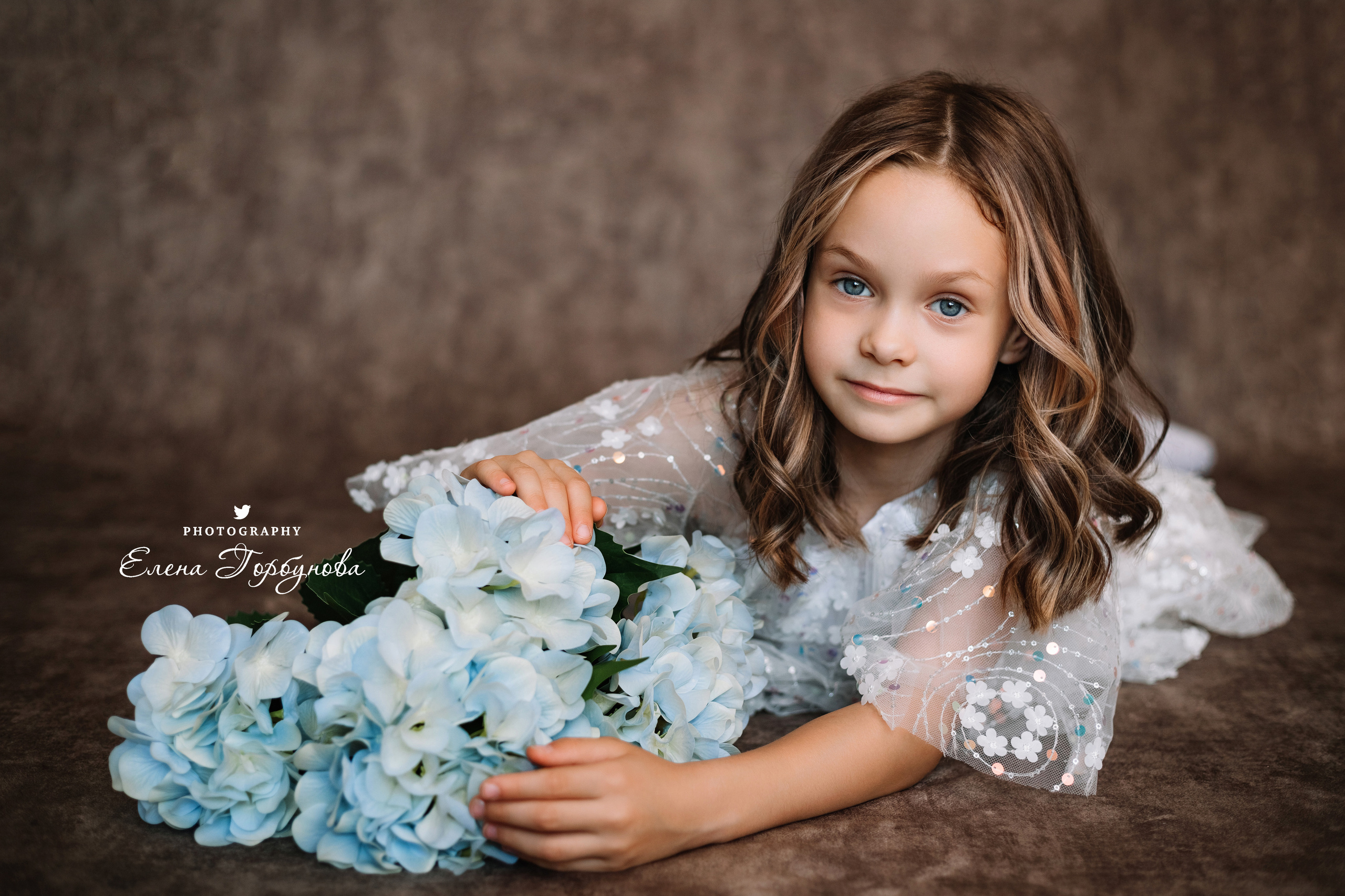 Фотосессия в садике Пермь фотограф Елена Гобунова Девочка в белом платье позирует на стуле с цветами Открытка для мамы. Детская фотосессия. Детский портрет в студии