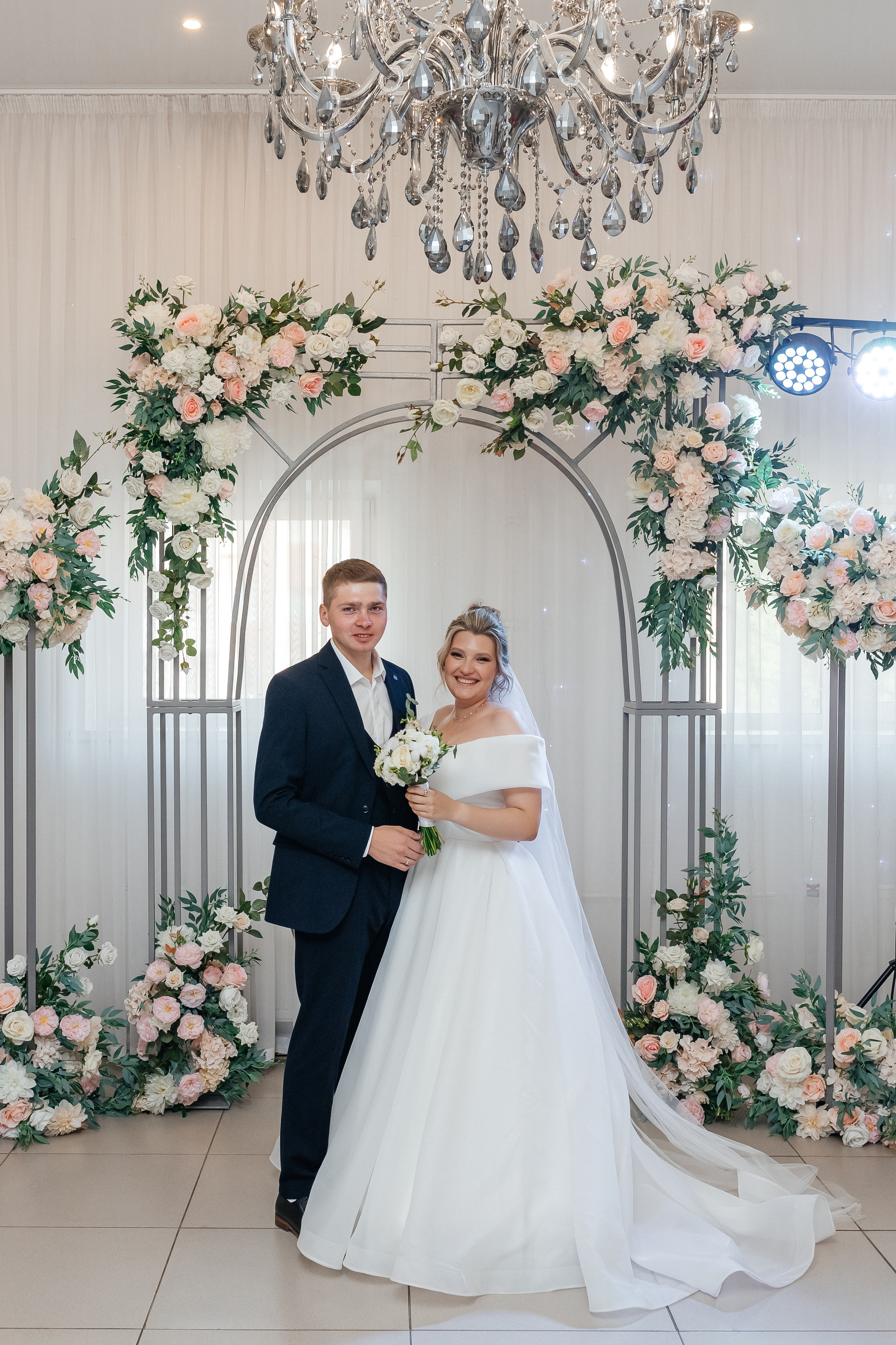 Жених и невеста, портрет, в красивом зале с большой люстрой