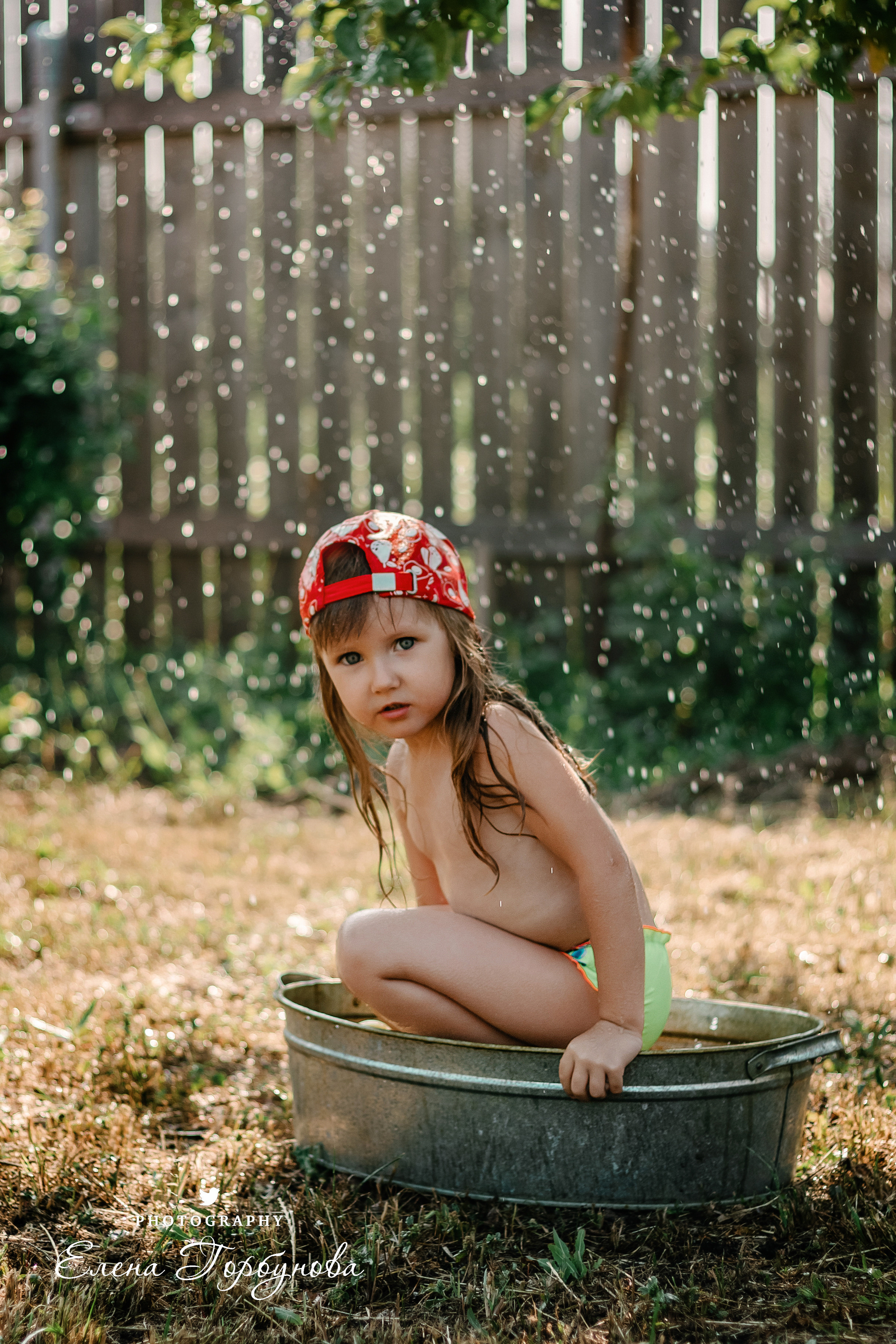 Детская фотосессия на природе на даче летом в тазике под яблоней с брызгами воды, с фонтаном