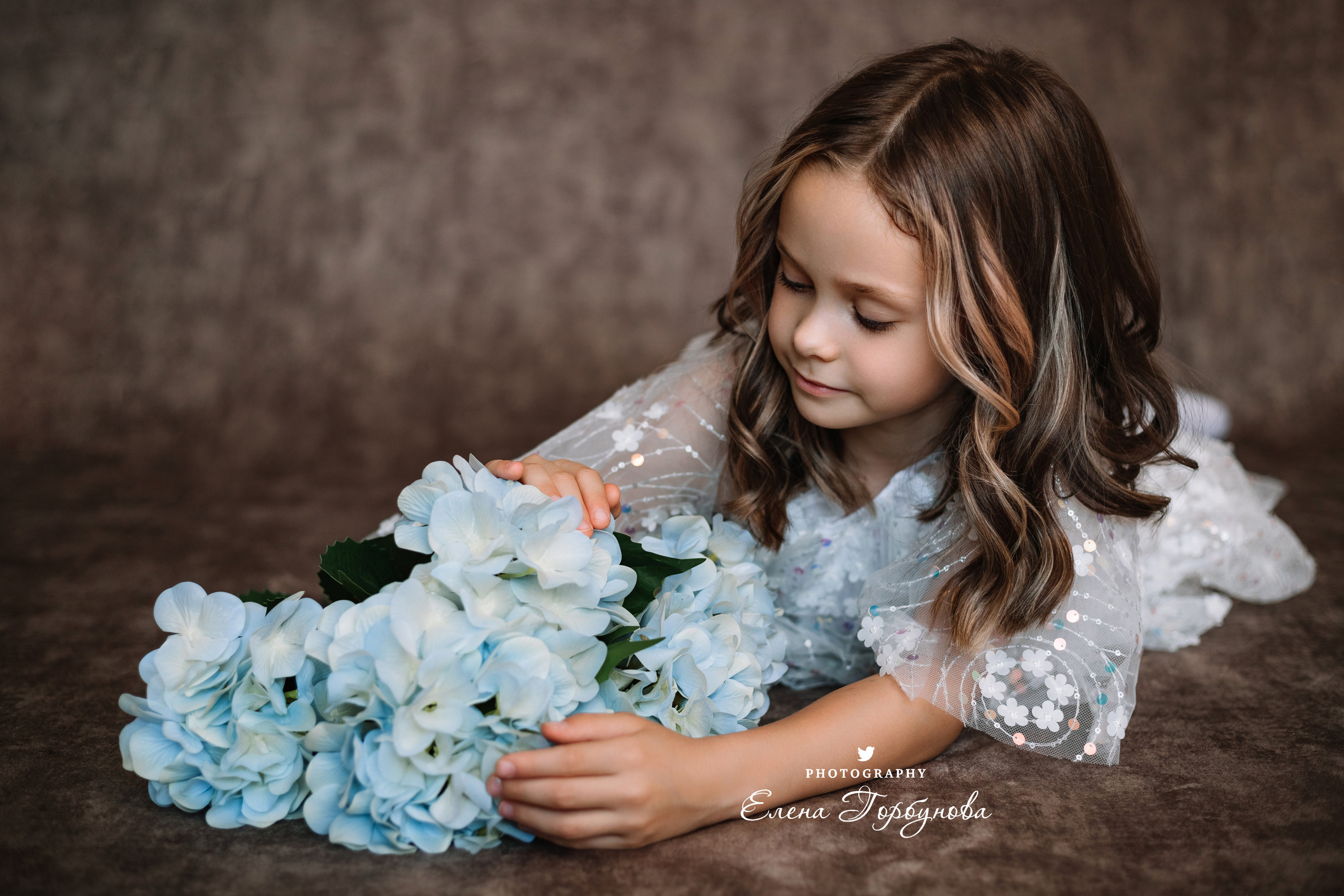 Фотосессия в садике Пермь фотограф Елена Гобунова Девочка в белом платье позирует на стуле с цветами Открытка для мамы. Детская фотосессия. Детский портрет в студии