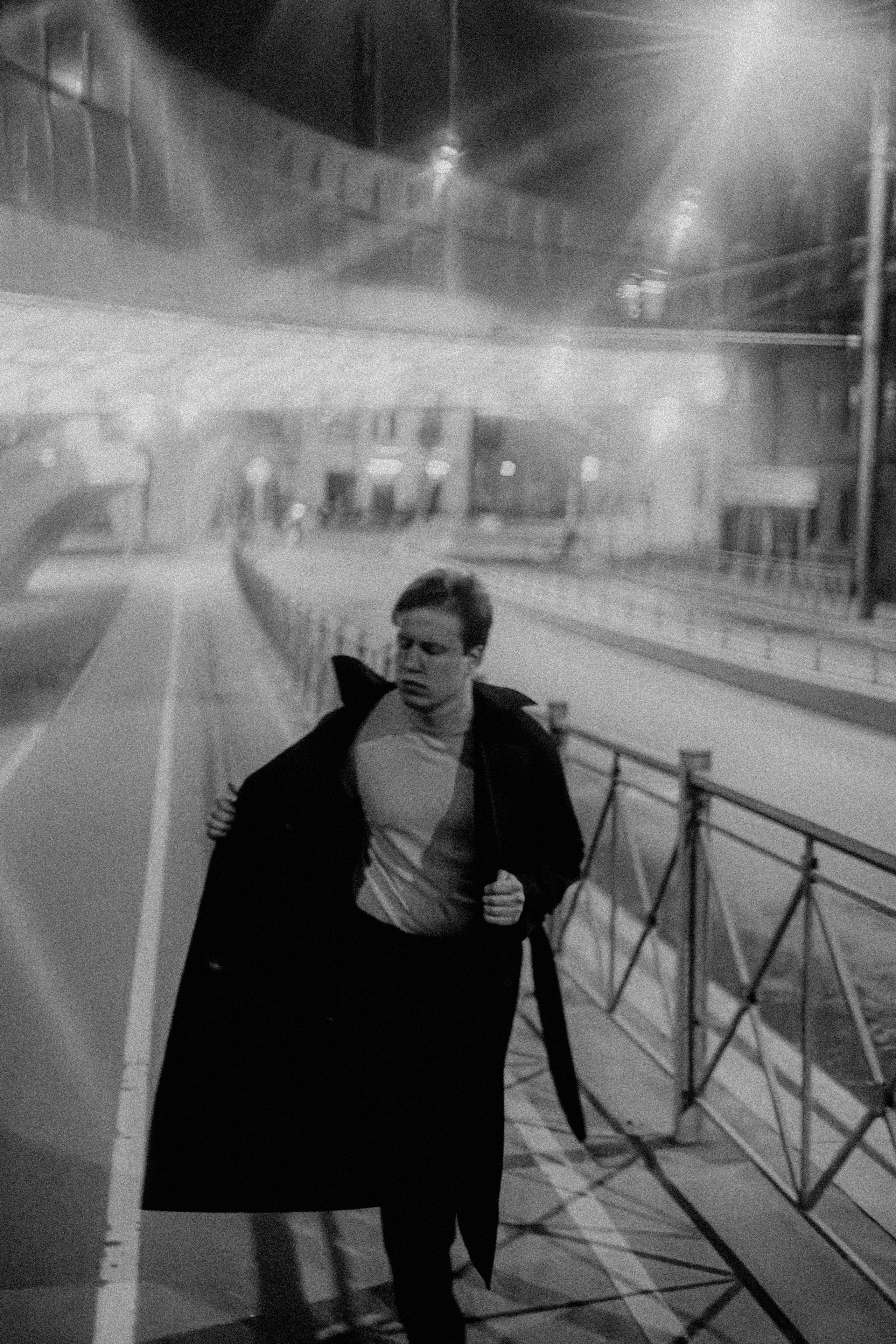 Мужчина идет в плаще ночью