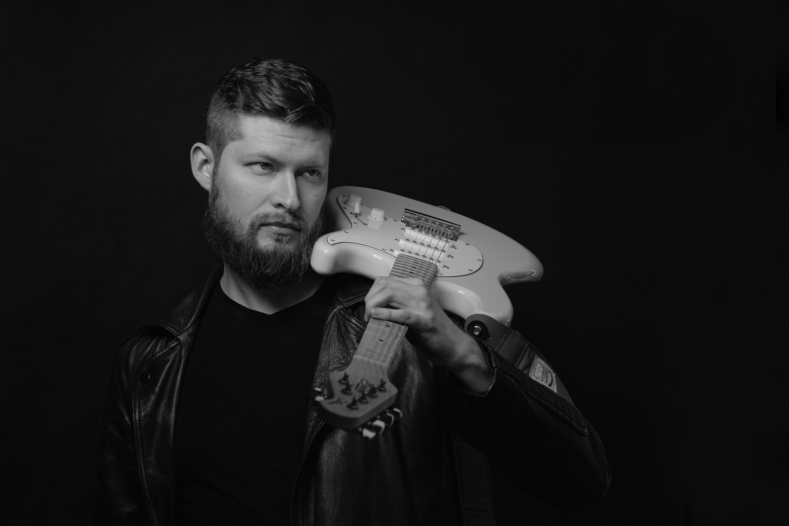 Мужской портрет гитариста держащего музыкальный инструмент в руках