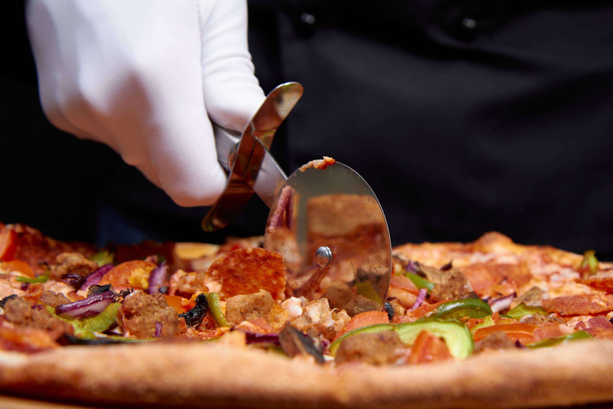 Съёмка ножа для пиццы режет пиццу