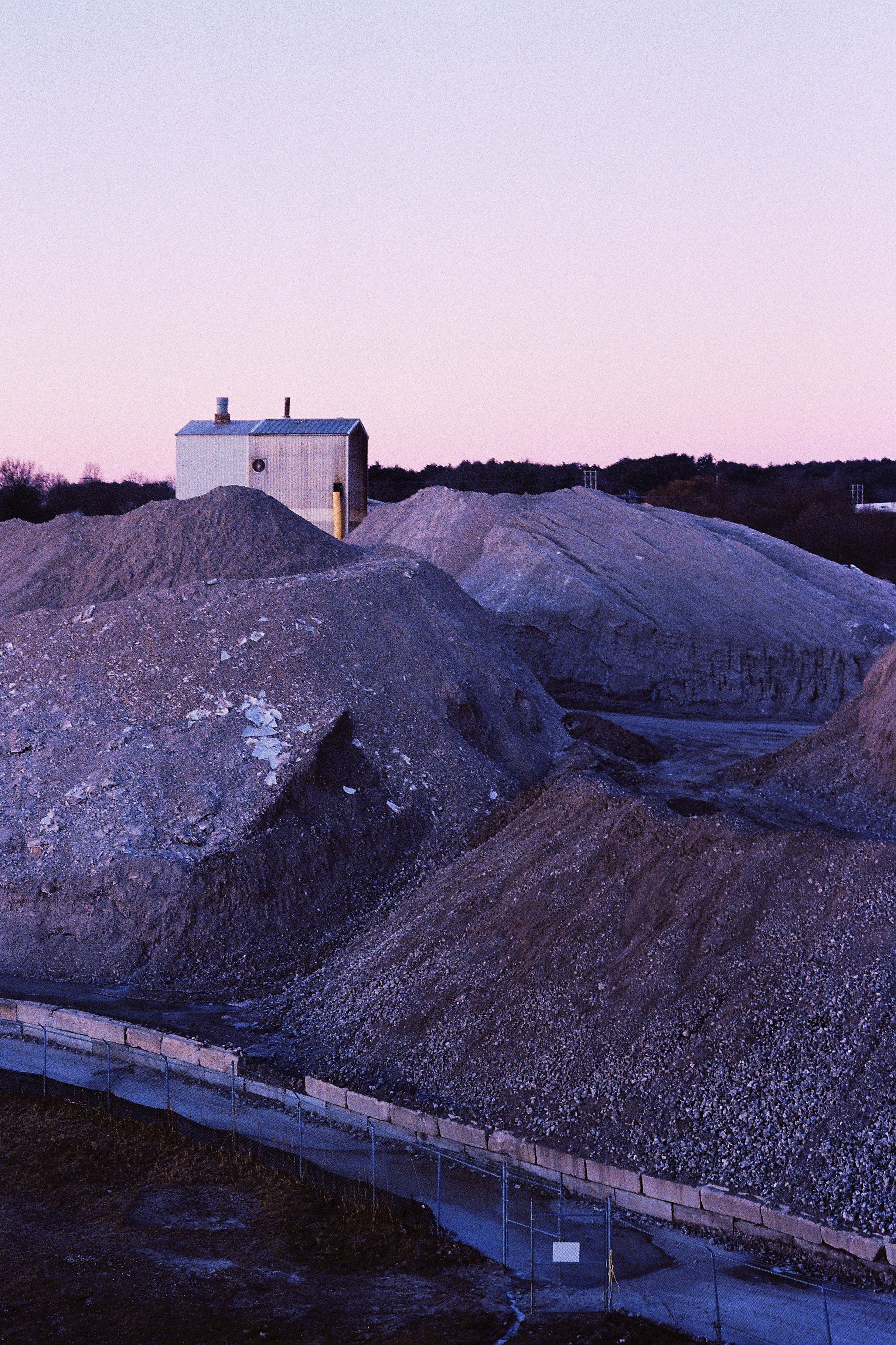 Антиутопичный постапокалиптичный вид на насыпи гальки в морском порту в рассвет