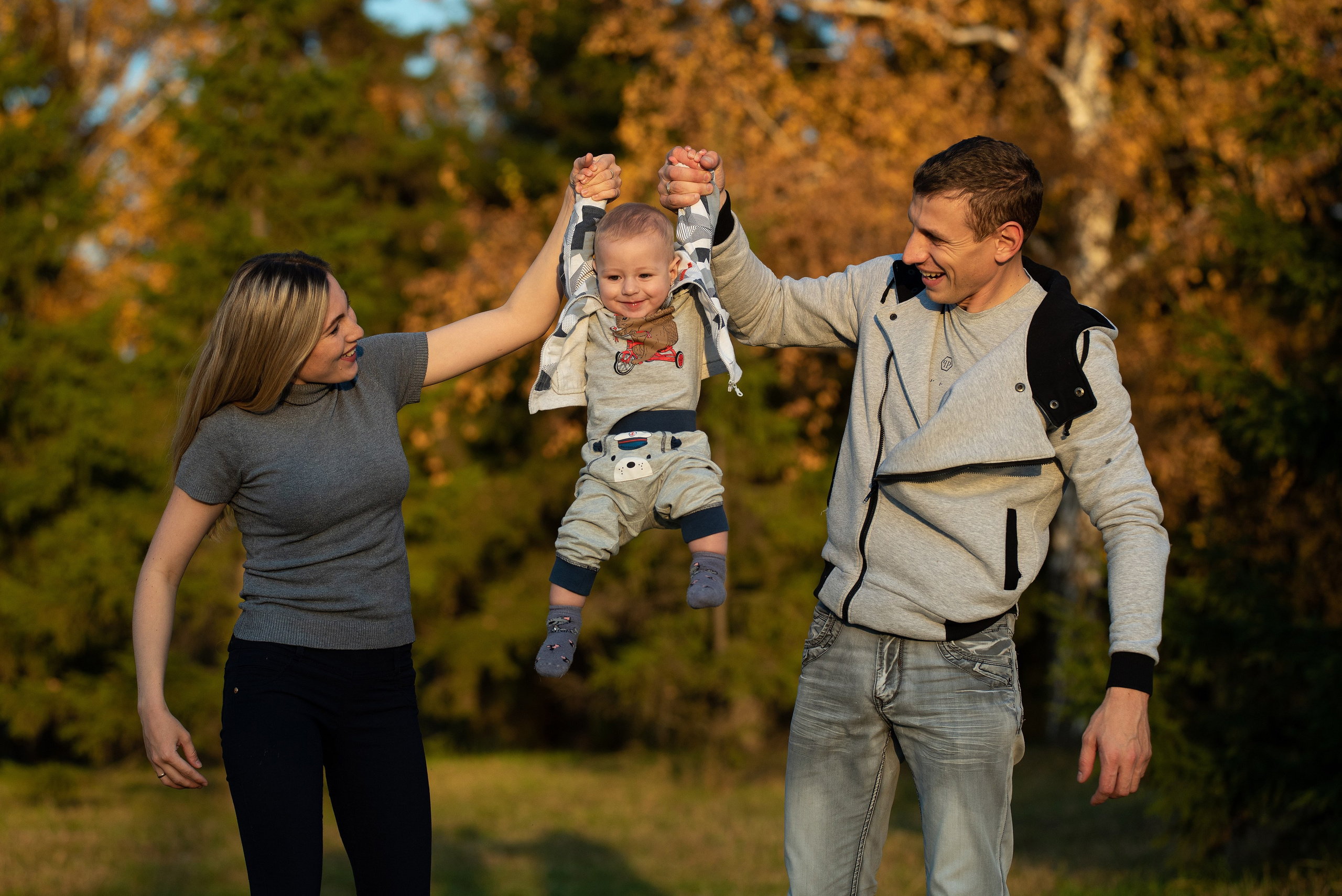 Родители подняли ребенка за руки.