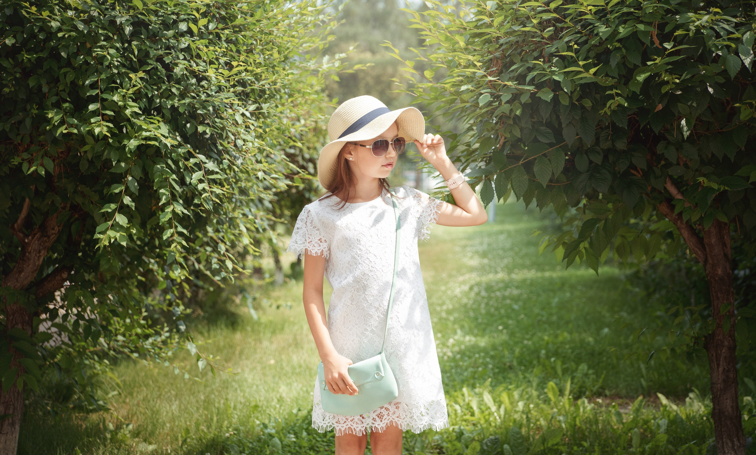 Детская фотосессия летом - девочка стоя смотрит по сторонам