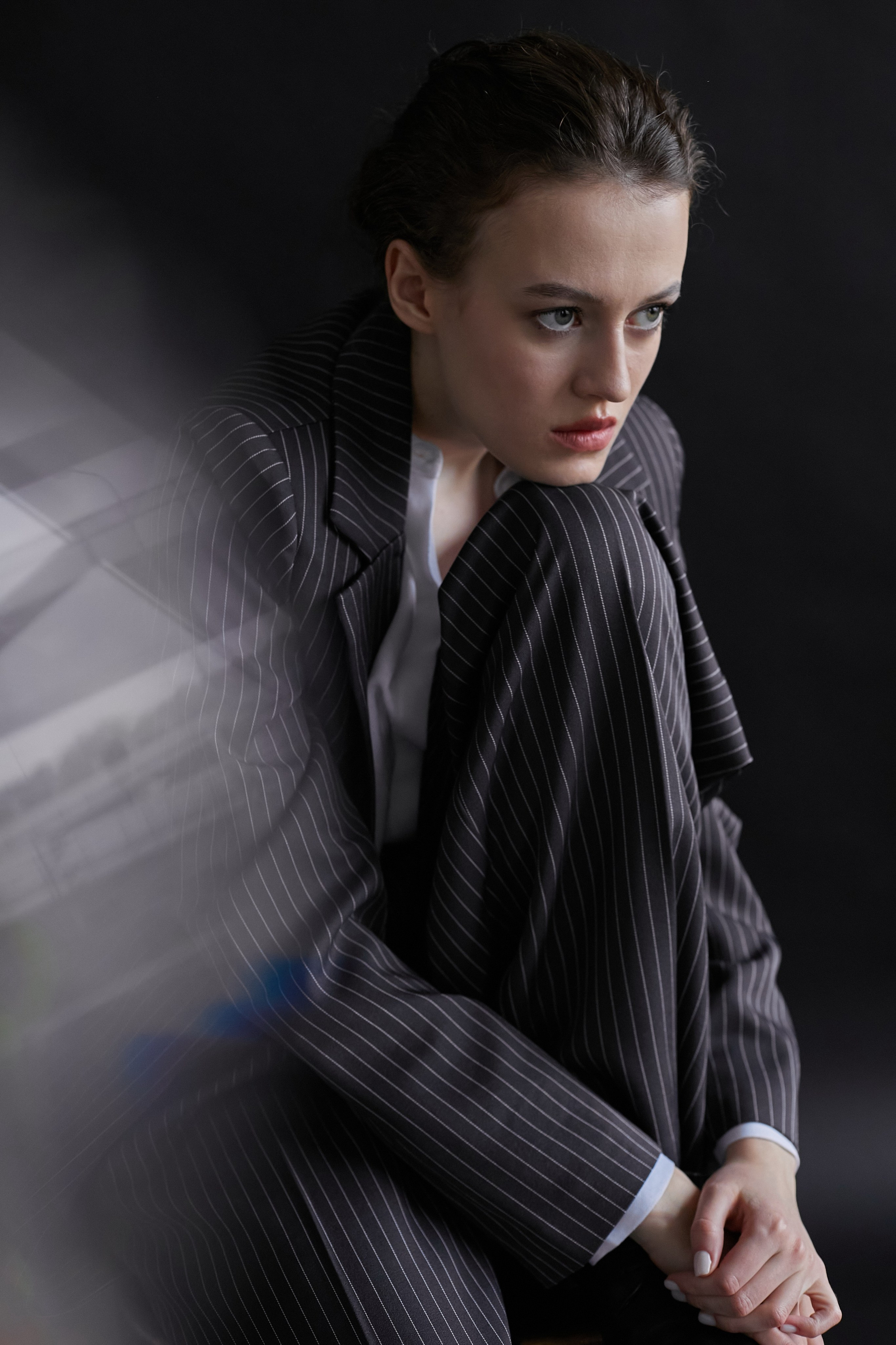 Фотограф в Москве. Студия. Студийный портрет. Девушка в пиджаке. Девушка на стуле на черном фоне. Красивая девушка в мужском костюме. Женский портрет.