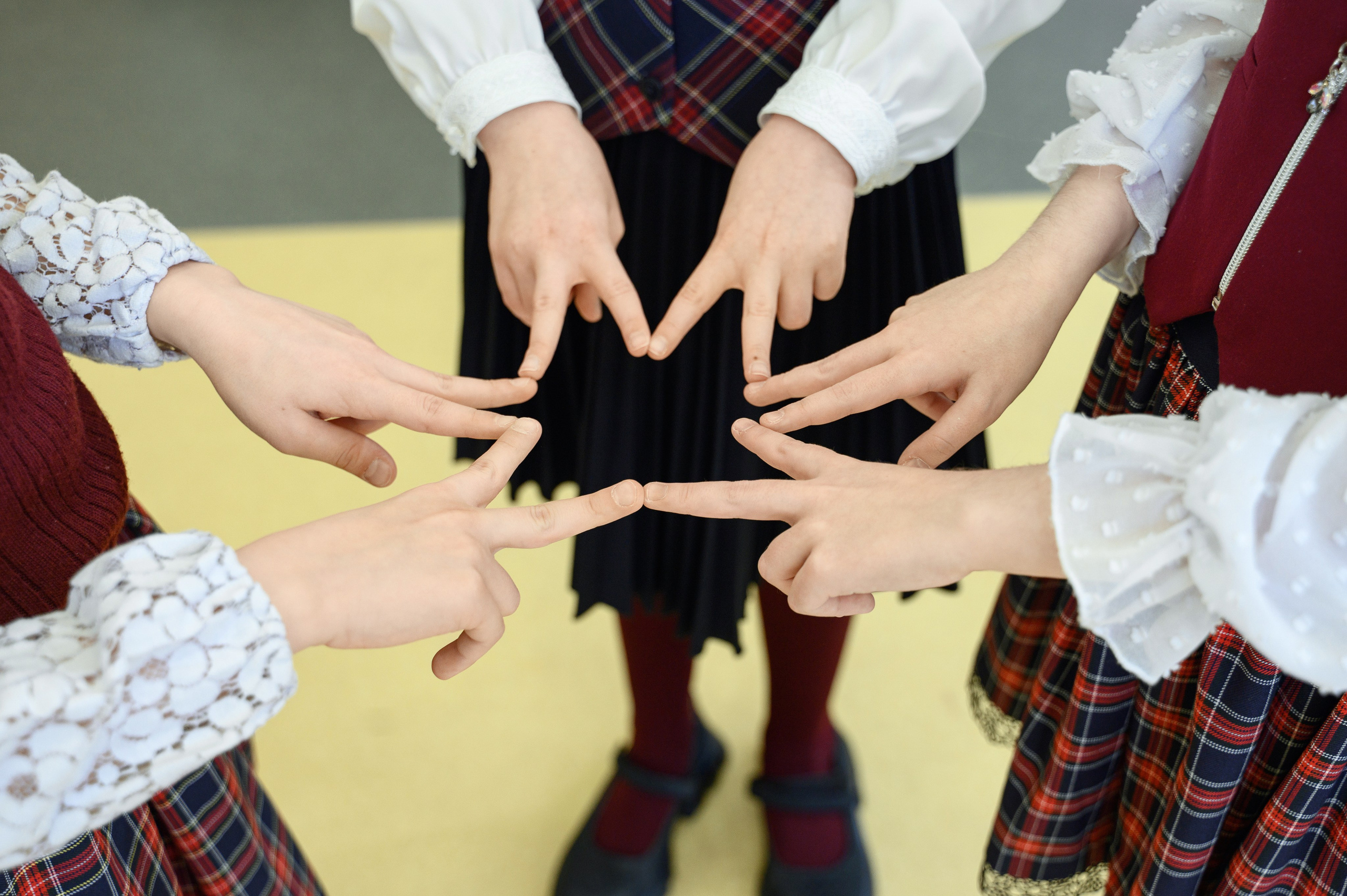 Командный жест школьников с руками в центре круга
