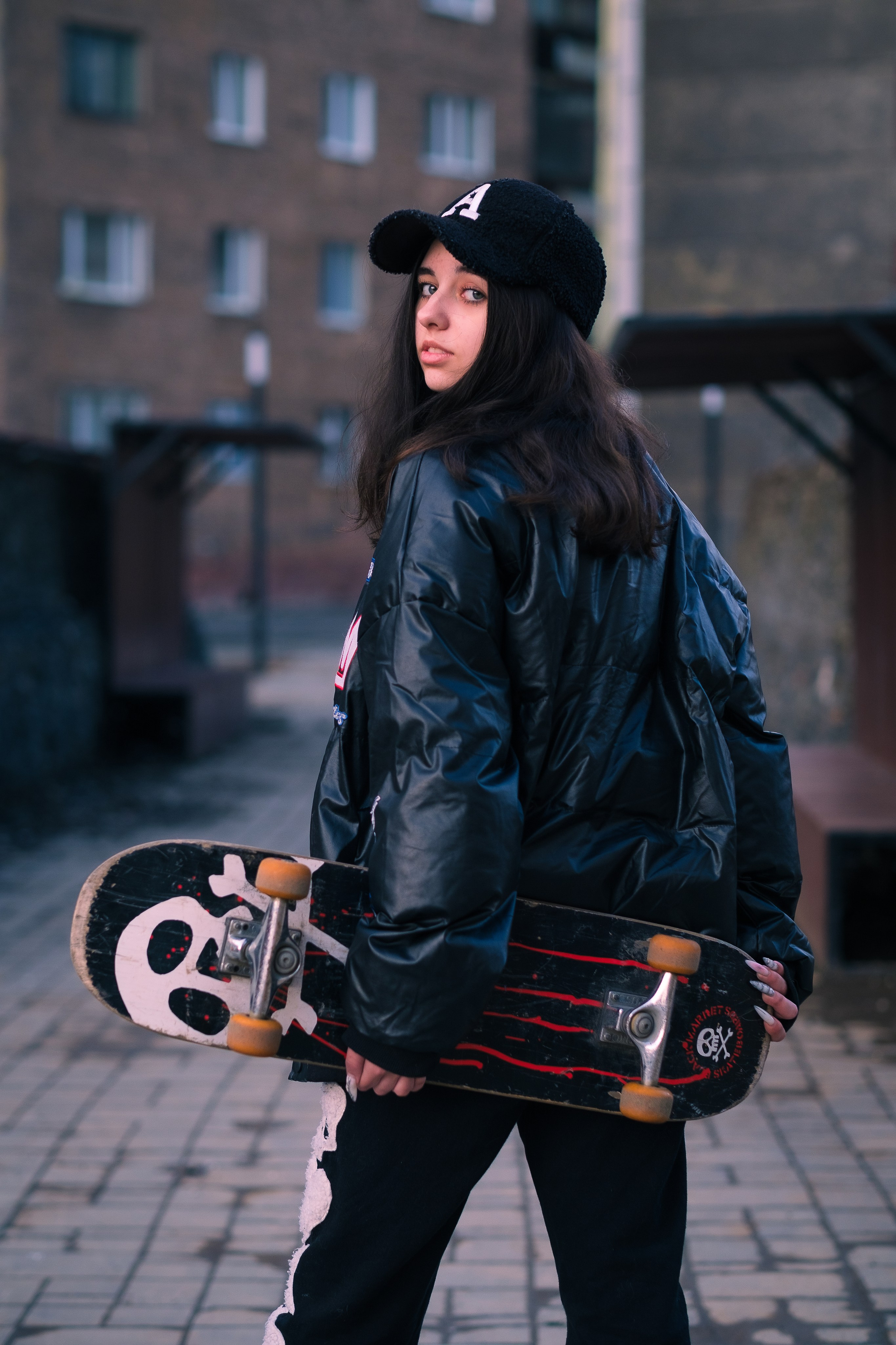 Девушка на улице со скейтбордом в руке