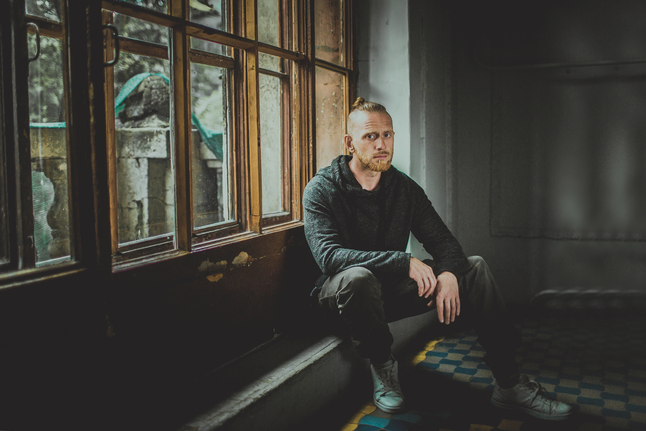 задумчивый мужчина сидит на лестничной площадке особняка начала века