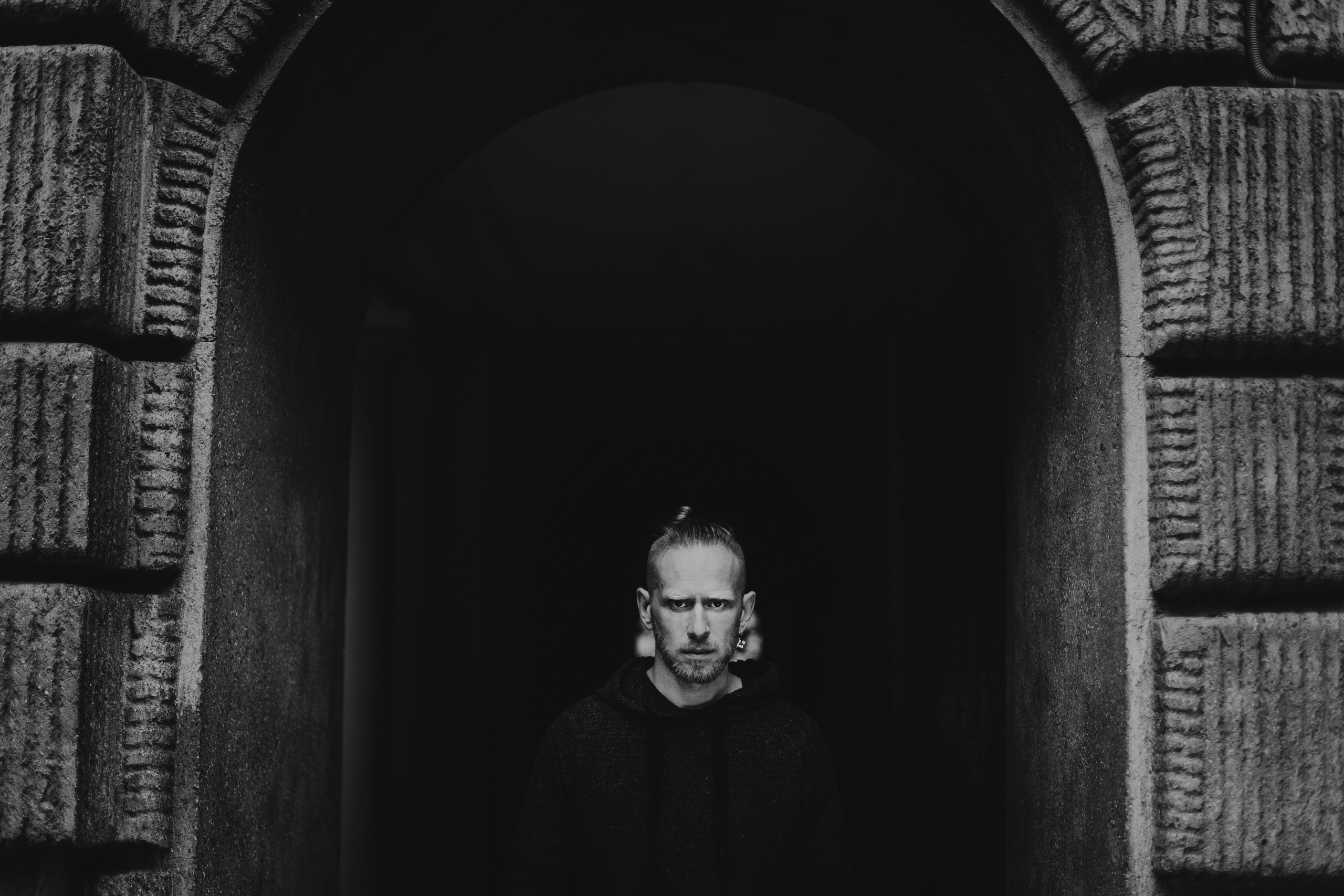 суровый мужчина выходит из-под дворовой арки в Санкт-Петербурге