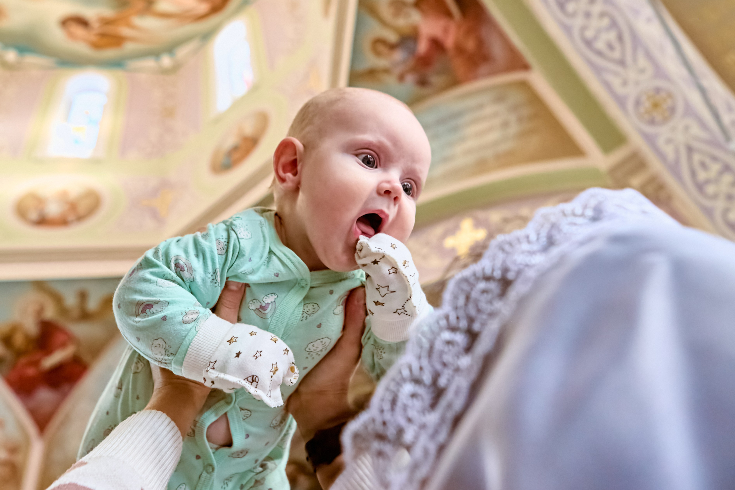 Фотосессия на Крещение. Православный фотограф Дзержинск Малыш на руках у крестной мамы держит над головой