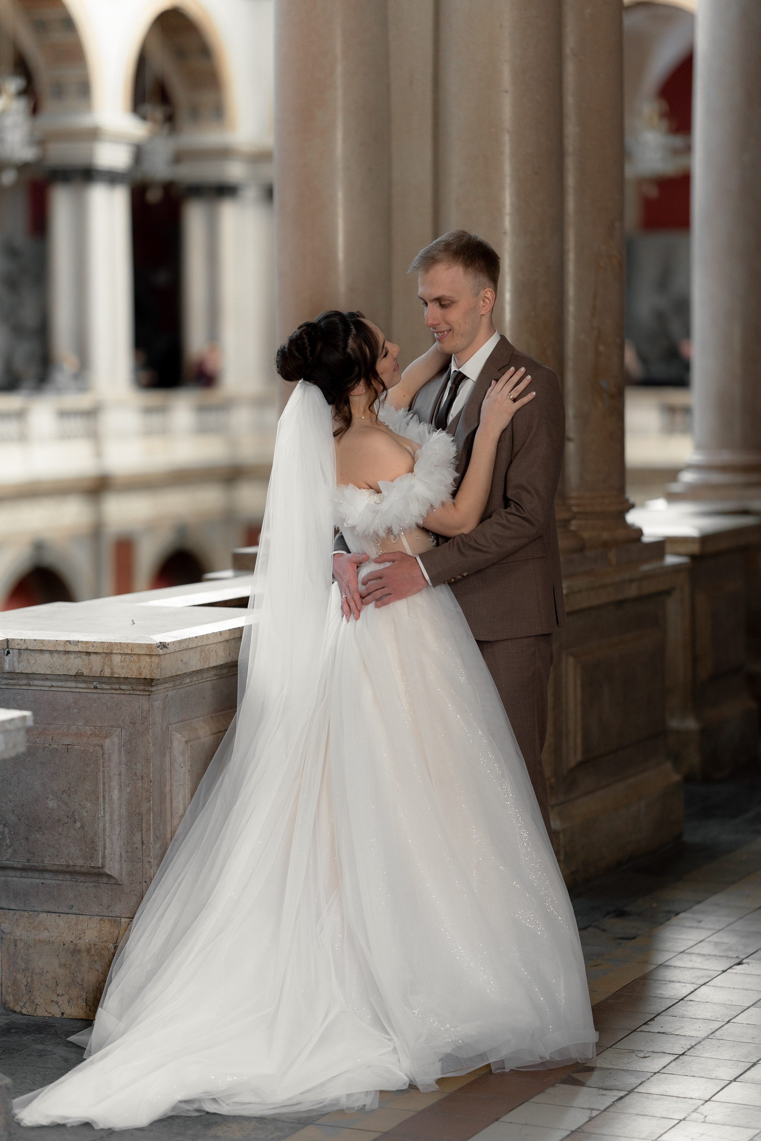 Невеста на свадебной фотосессии обнимает жениха в академии Штиглица