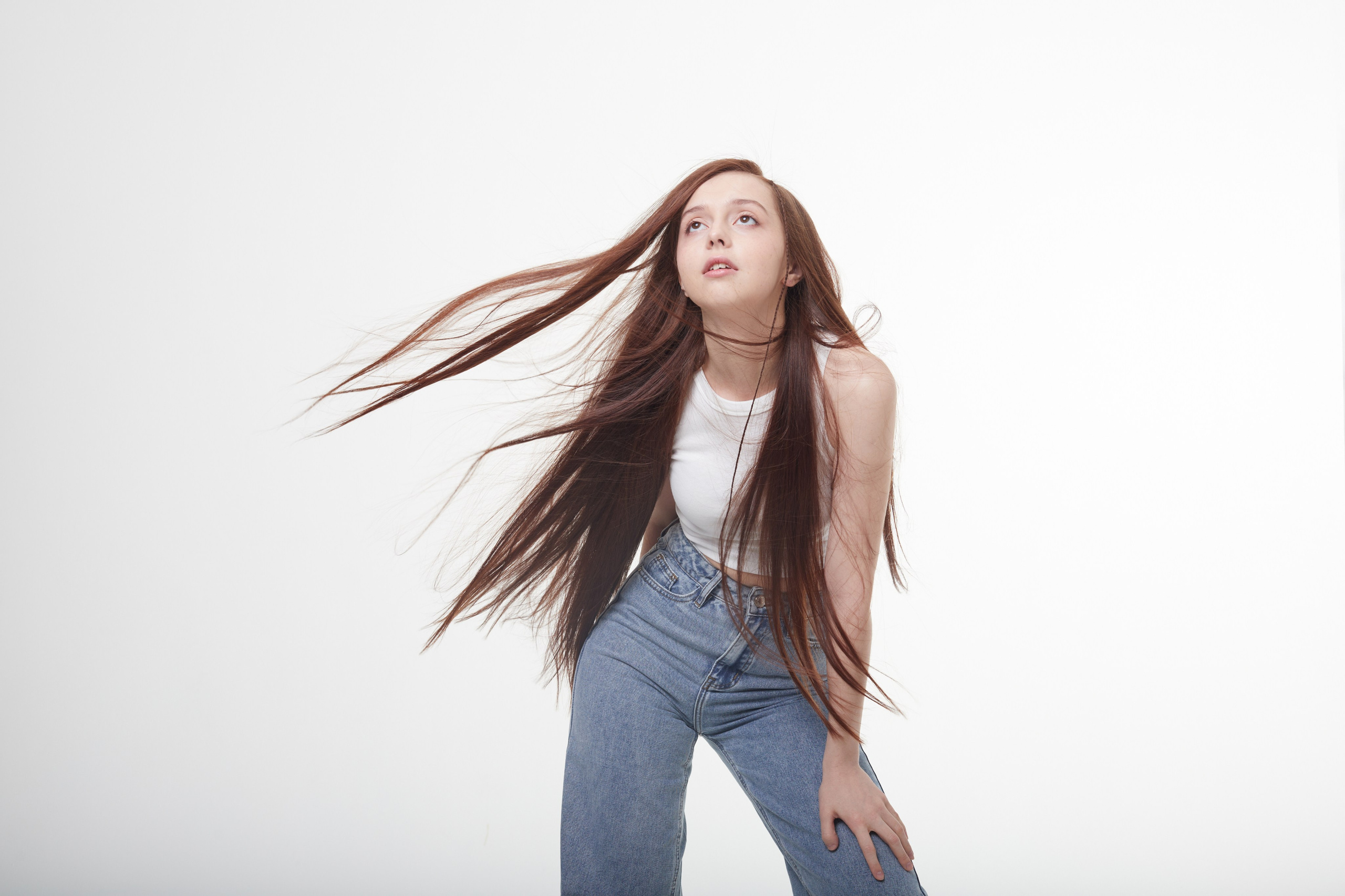 Студийная фотосессия девушки с развевающимися волосами.