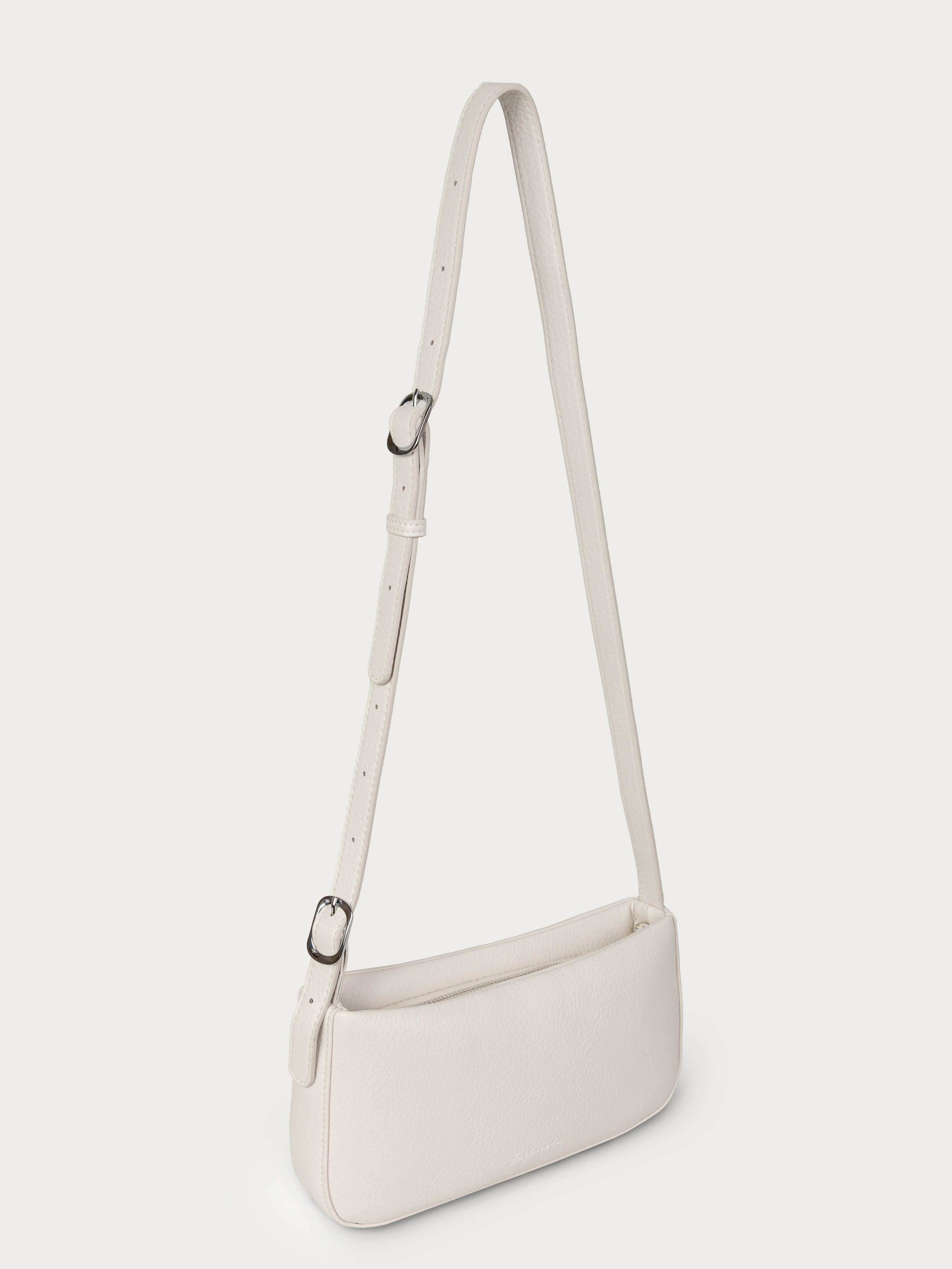 На фото белая дамская сумка с длинной ручкой-ремнем.
