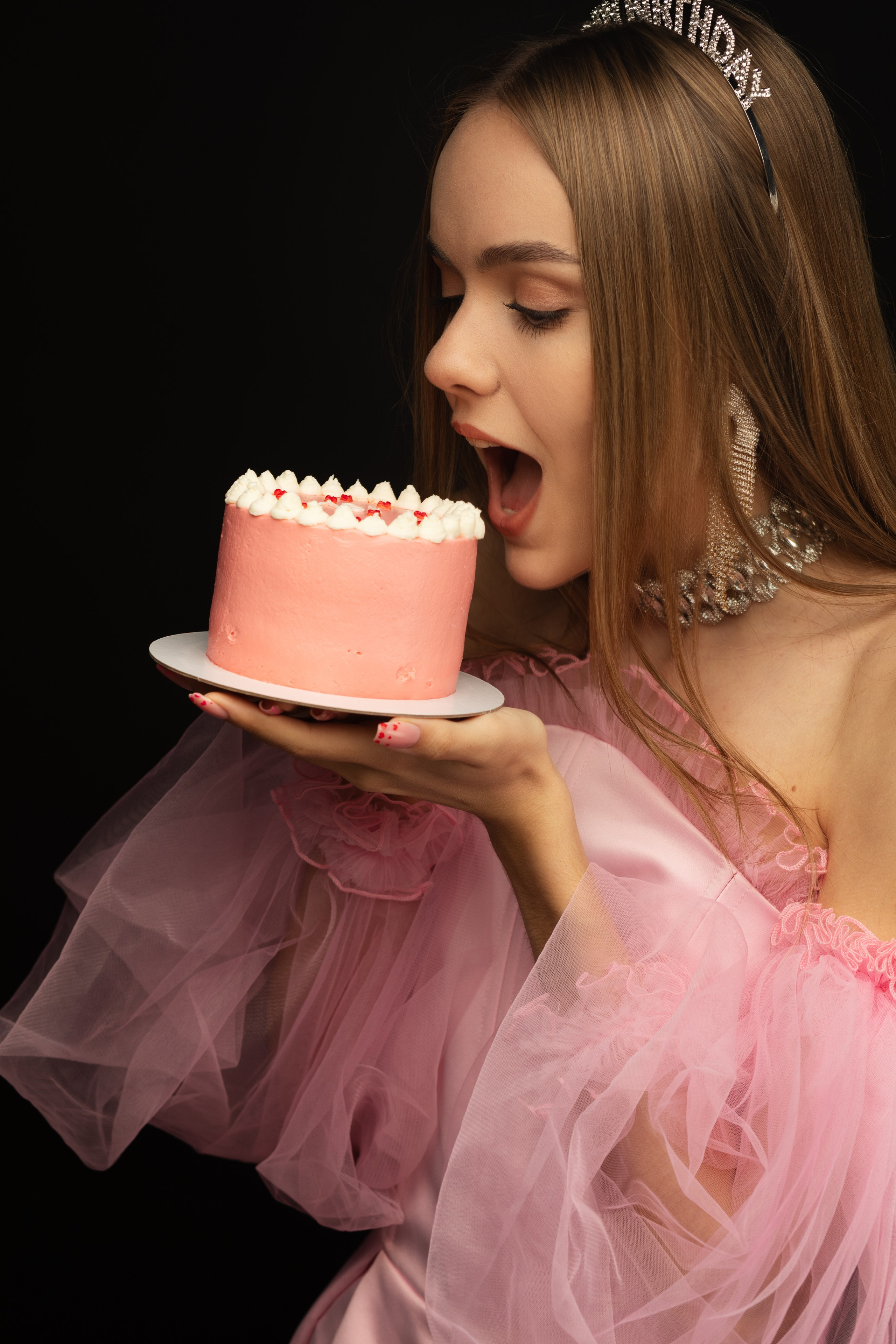 Девушка в день рождения кусает торт