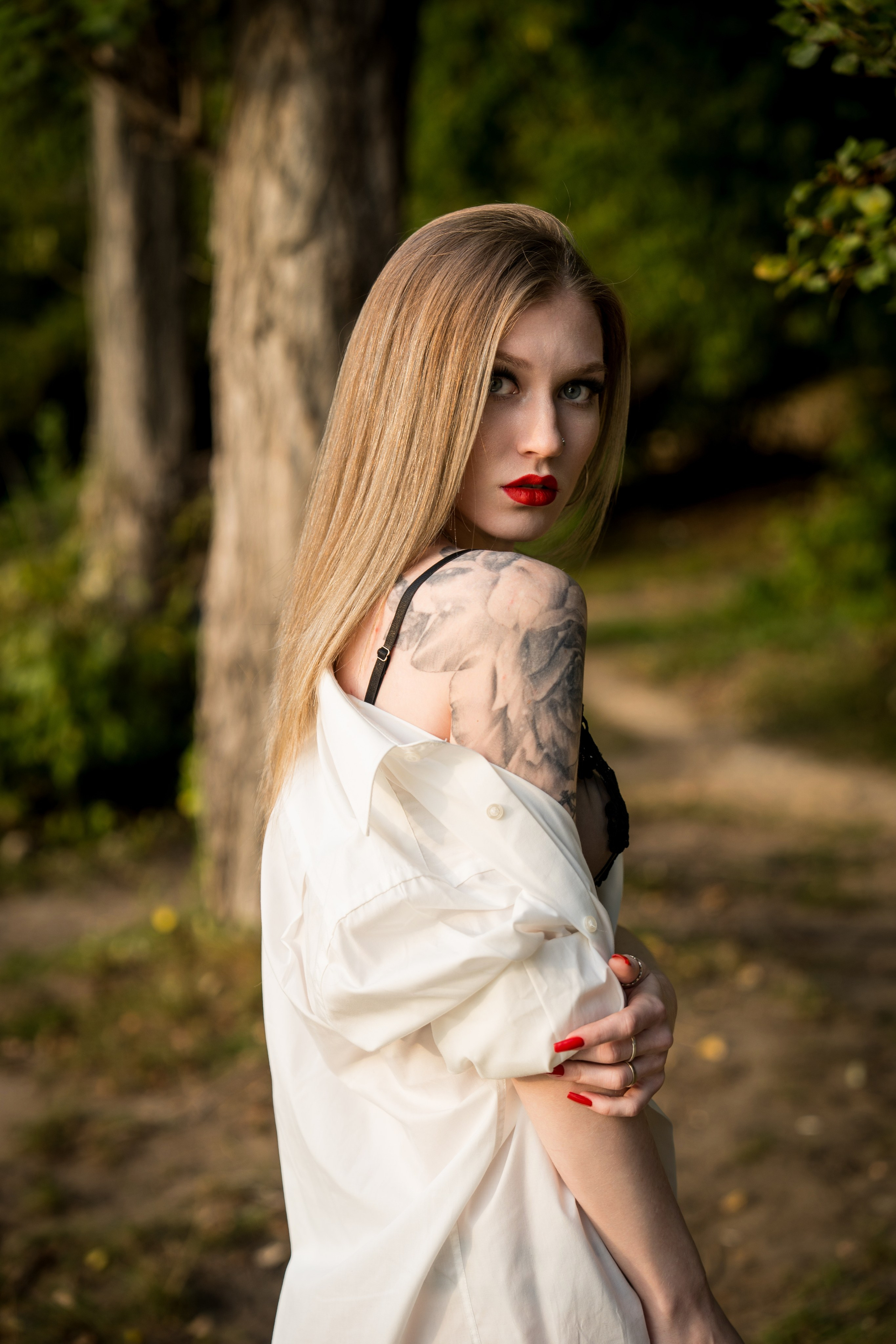 девушка в белой рубашке собирается купаться в реке