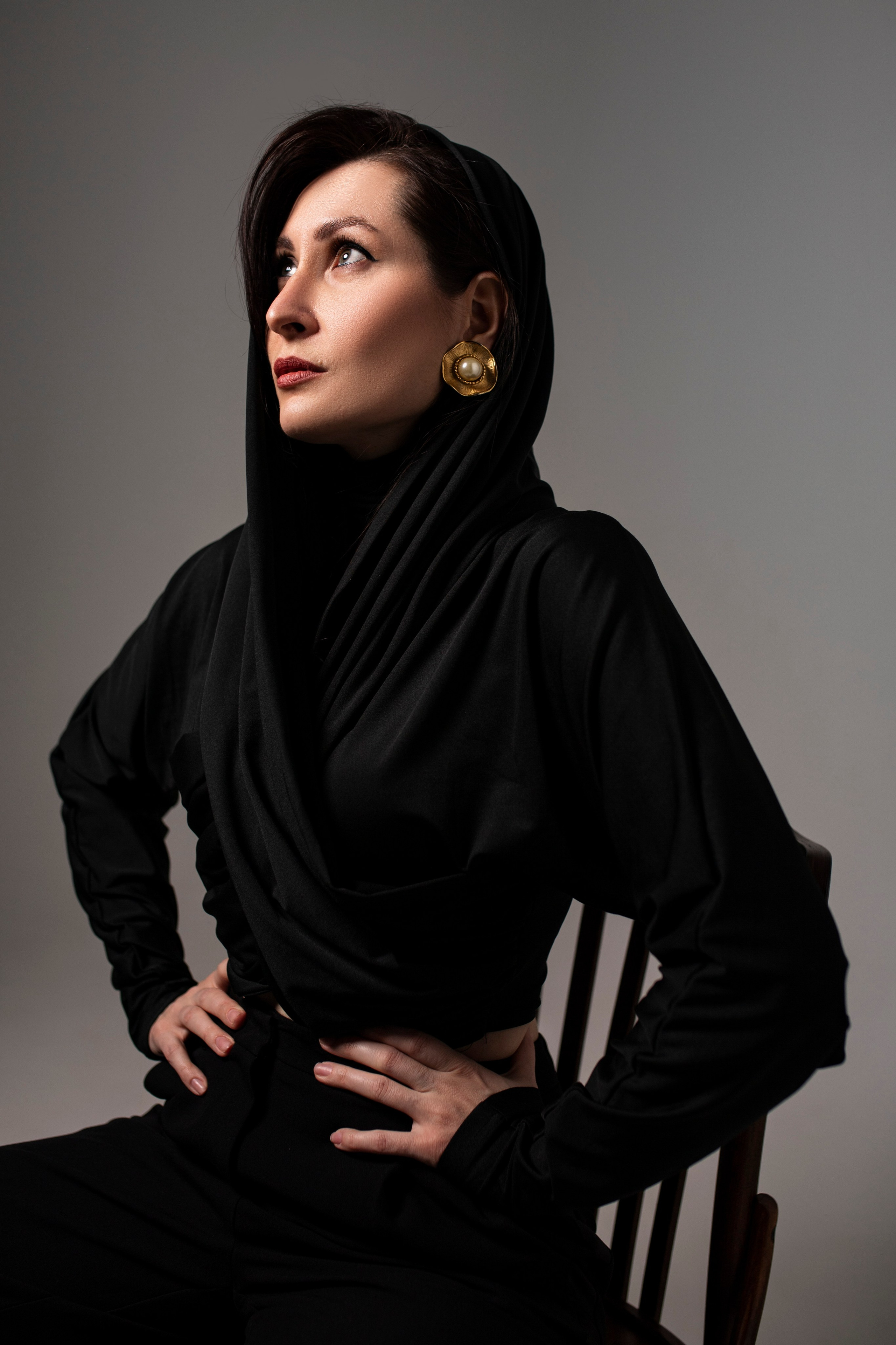 Студийный портрет девушки в черном с капюшоном