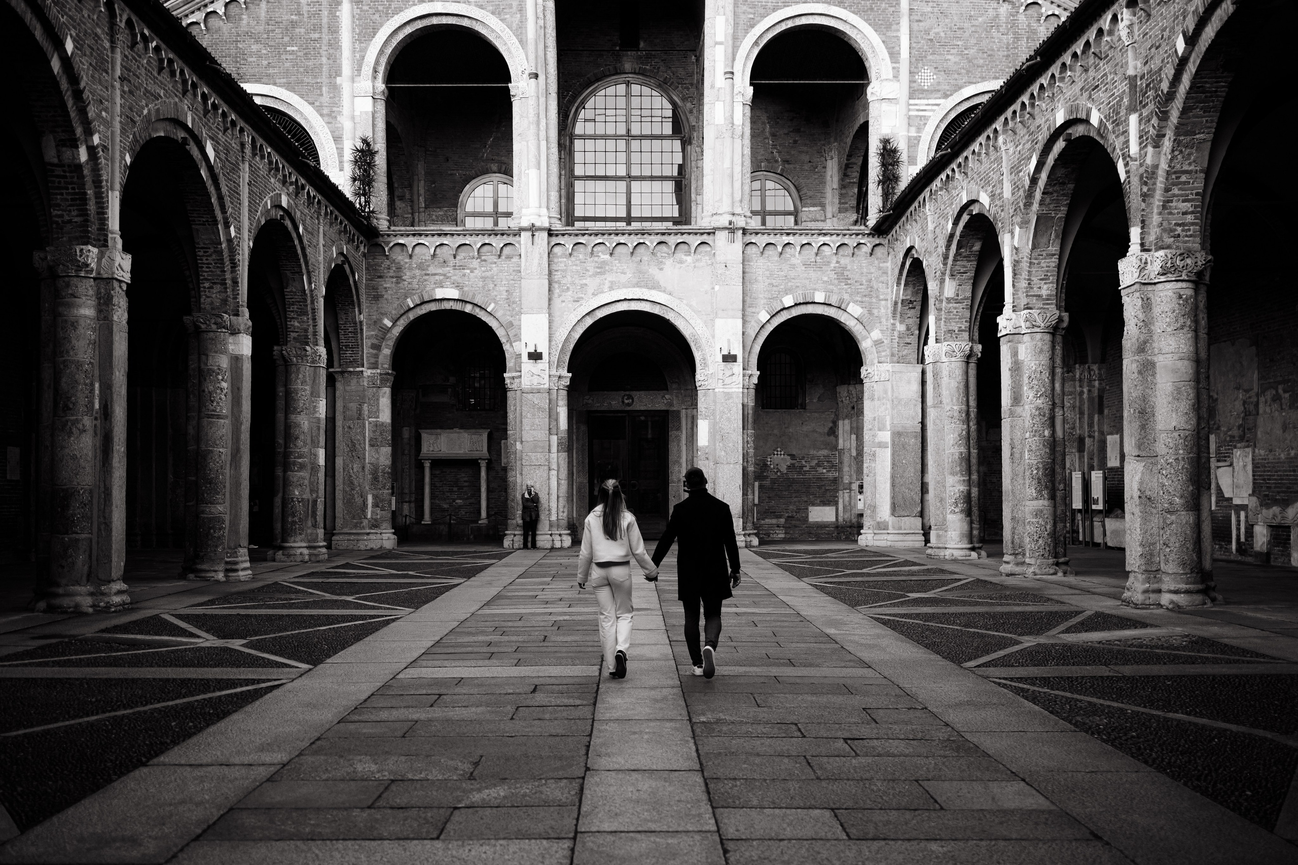 Пара в архитектурном пространстве, симметрия арок и шагов