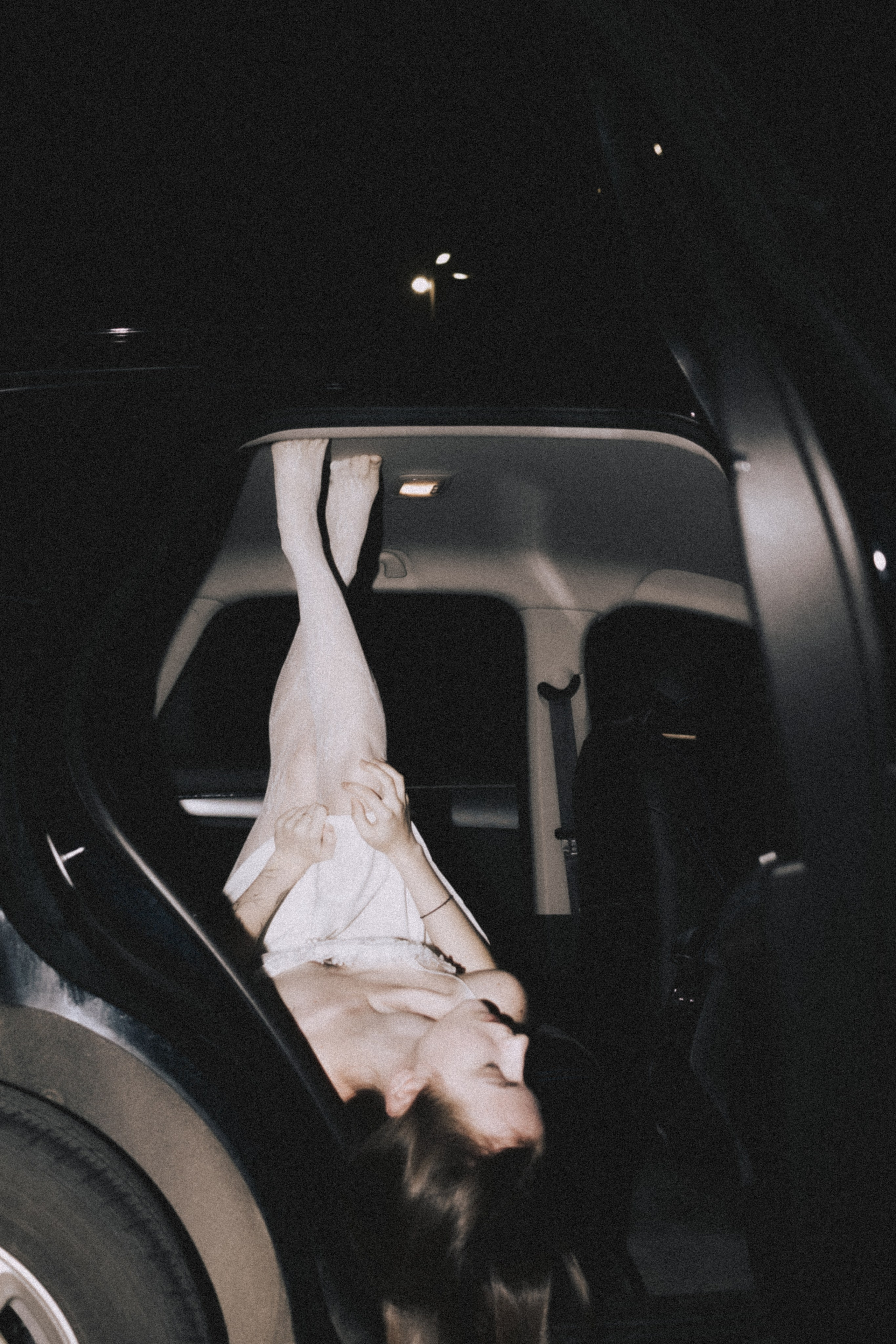 Фотосессия ночью в Пензе: ноги девушки торчат из окна черной машины. Фотограф Александра Овечкина