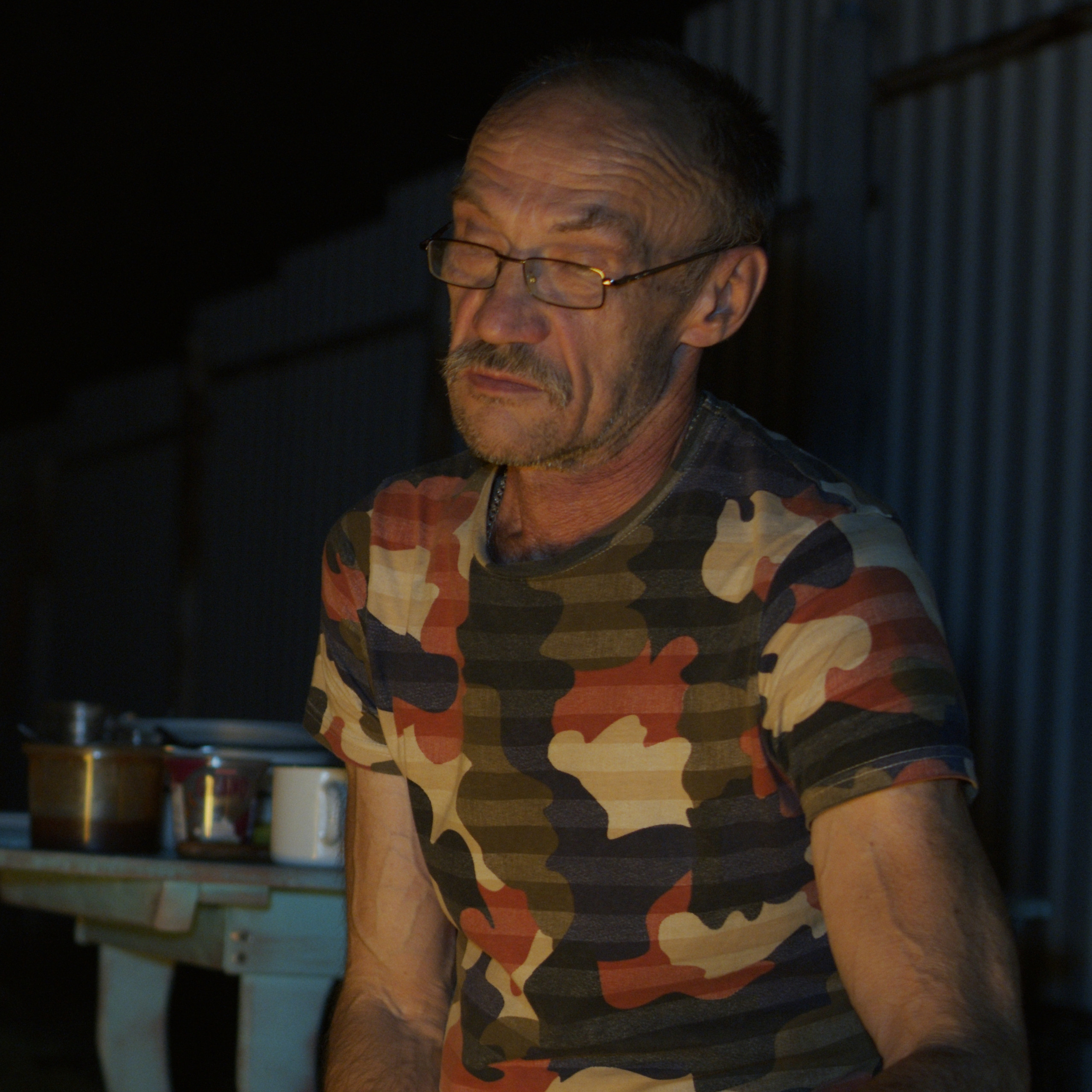 Вечер у костра летом, мужчина в очках.