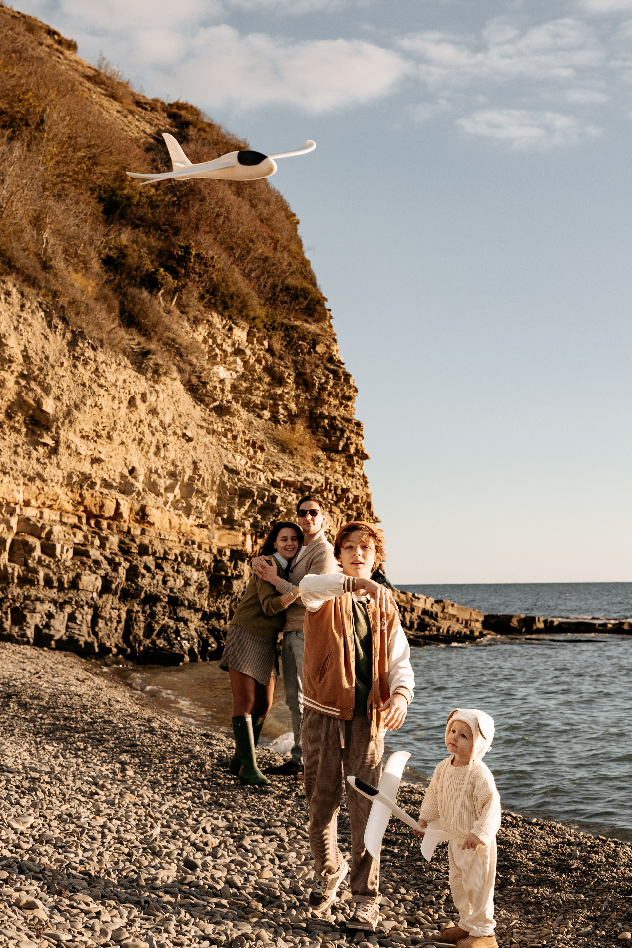 Дочь с восторгом смотрит на летящий бумажный самолетик