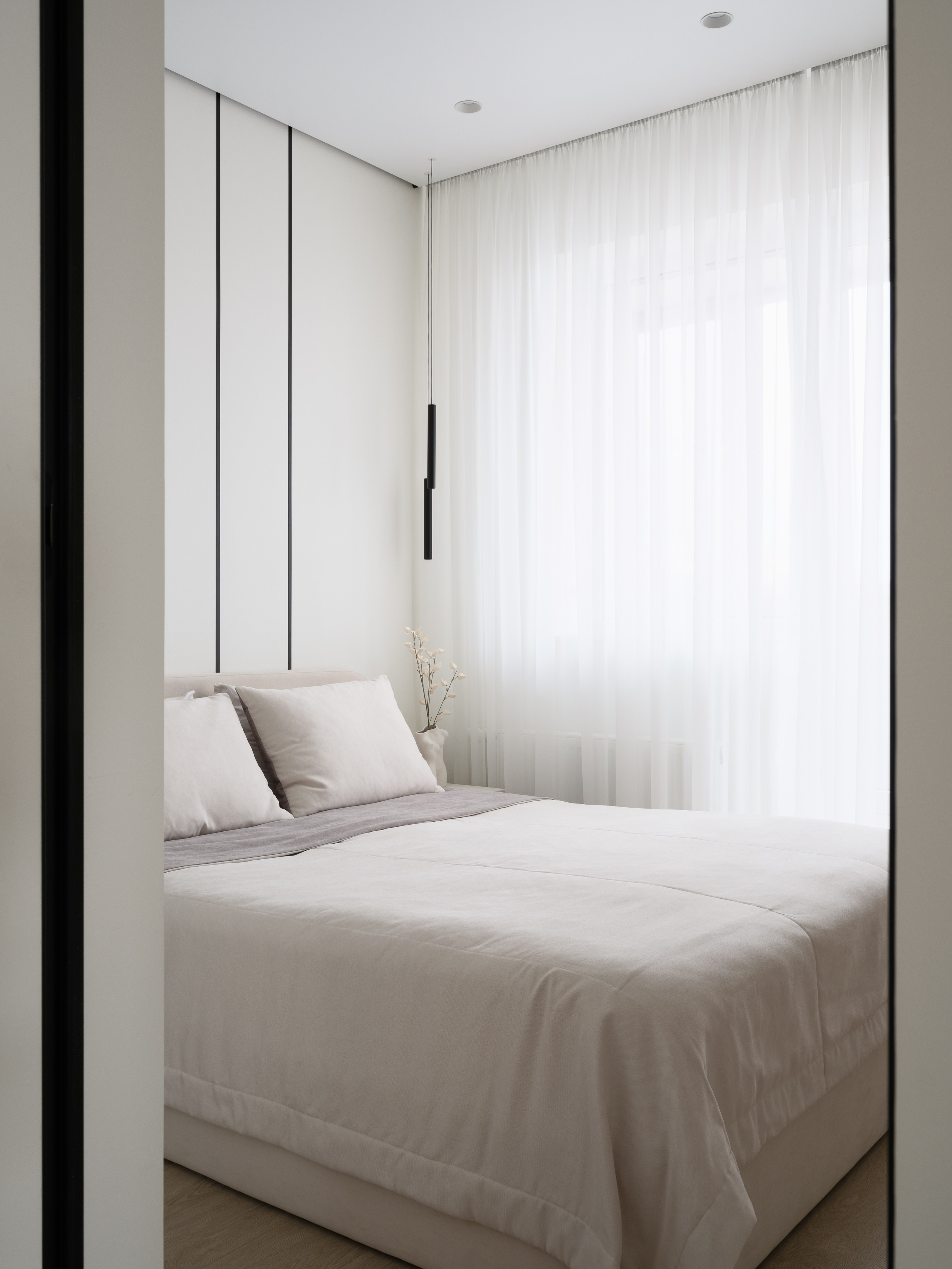Современная спальня в минималистичном стиле с двуспальной кроватью, белыми шторами и встроенными шкафами. Автор проекта — дизайнеры Евгения Княжева и Владлена Привалова, фотограф Сергей Денисенко