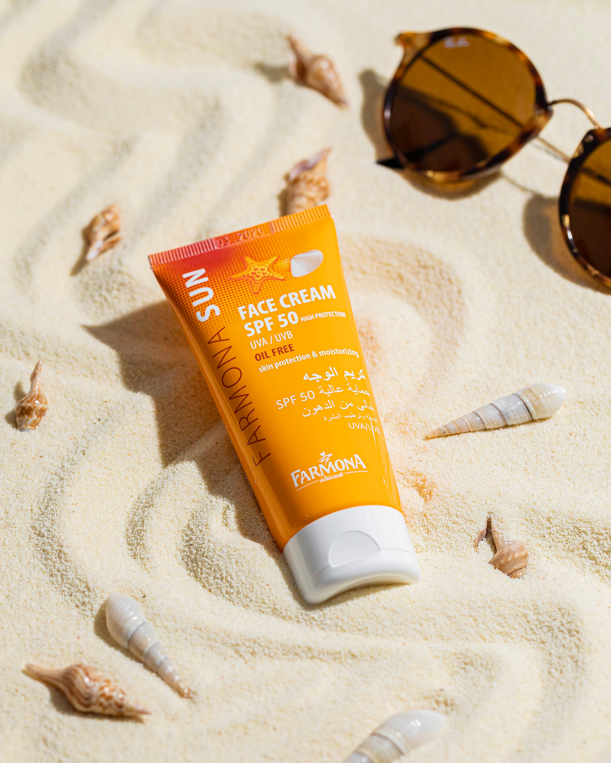 Крем от загара SPF 50 на плане на песке под лучами яркого солнца