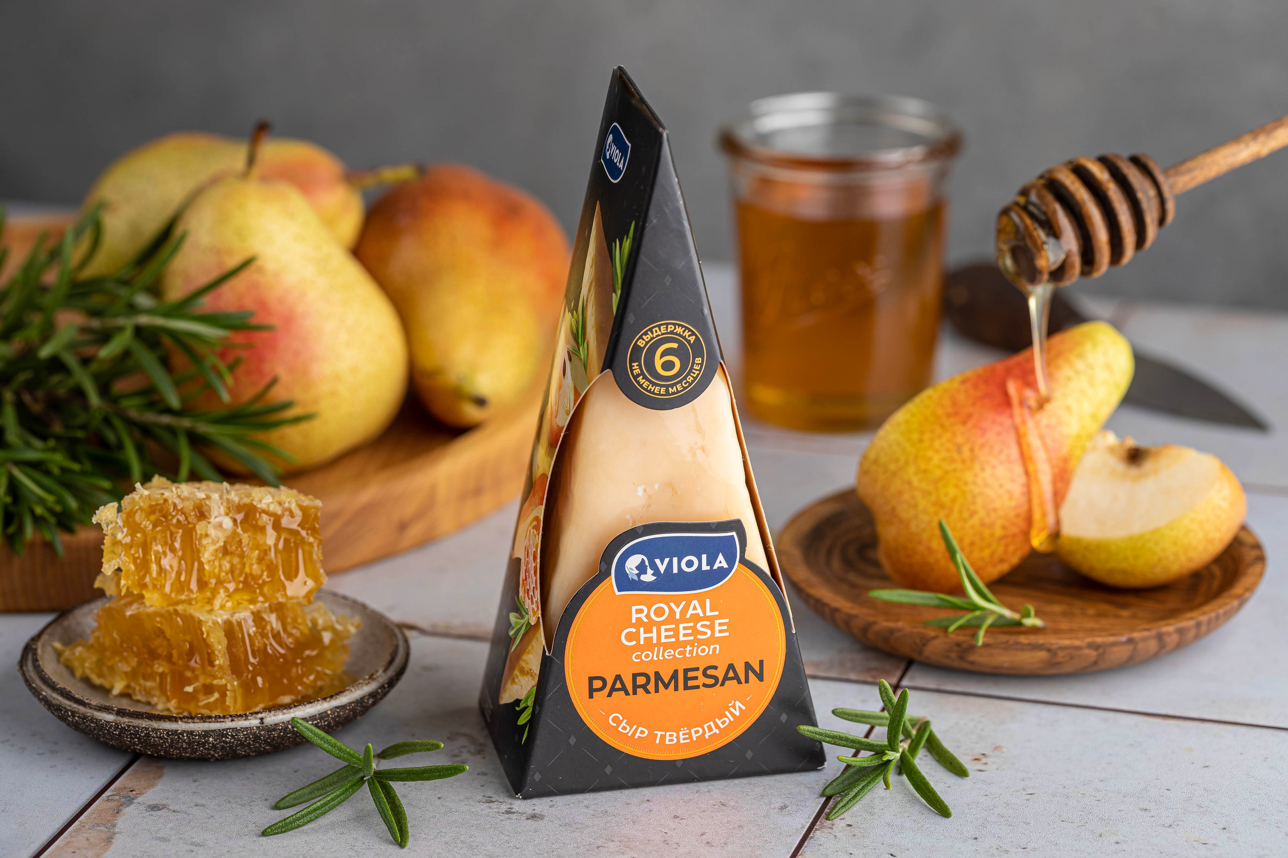 Рекламная съемка упаковки сыра Пармезан в композиции со свежей грушей и медом в сотах