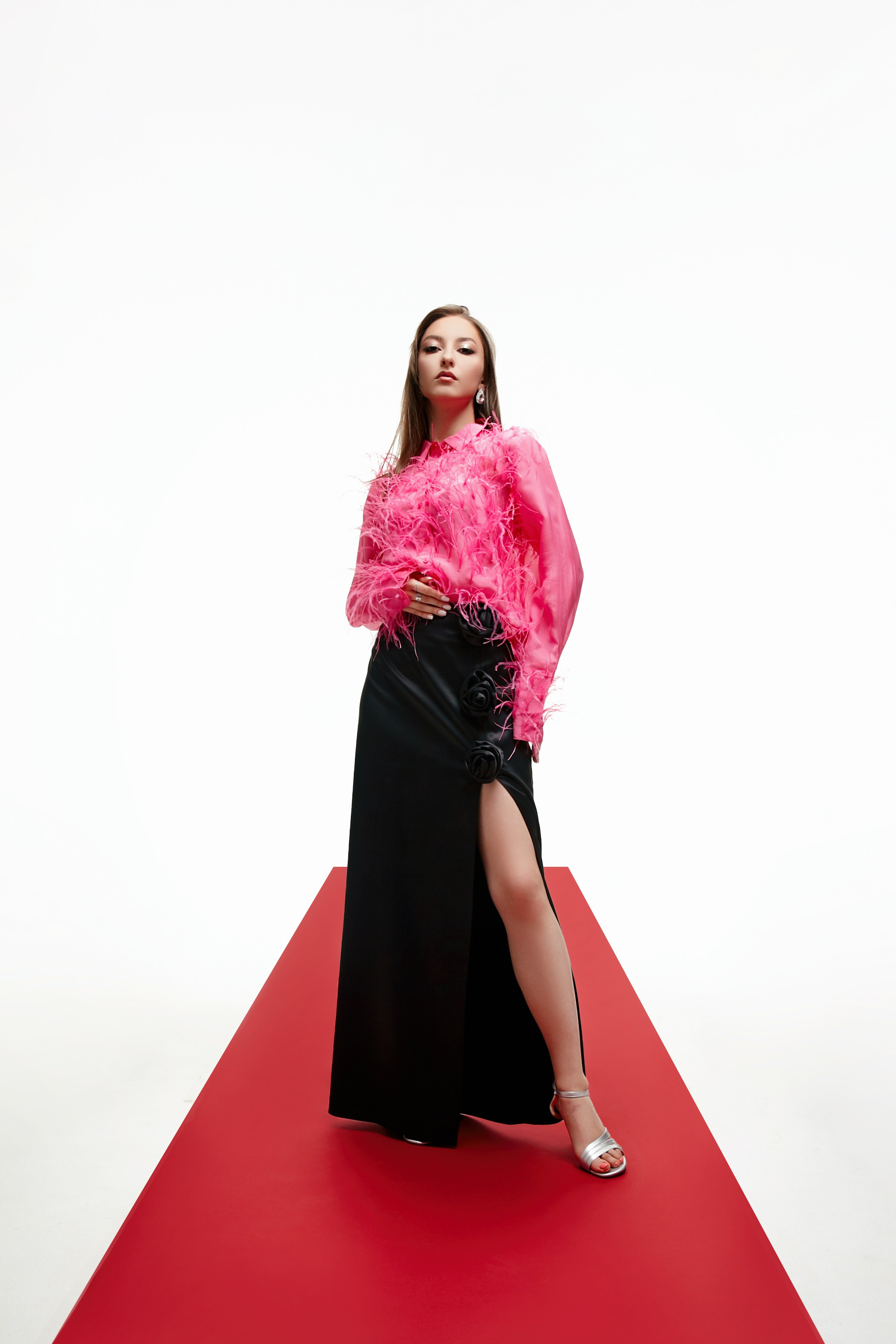 Девушка в розовой блузке с перьями Atelier star people на красной дорожке на белом фоне