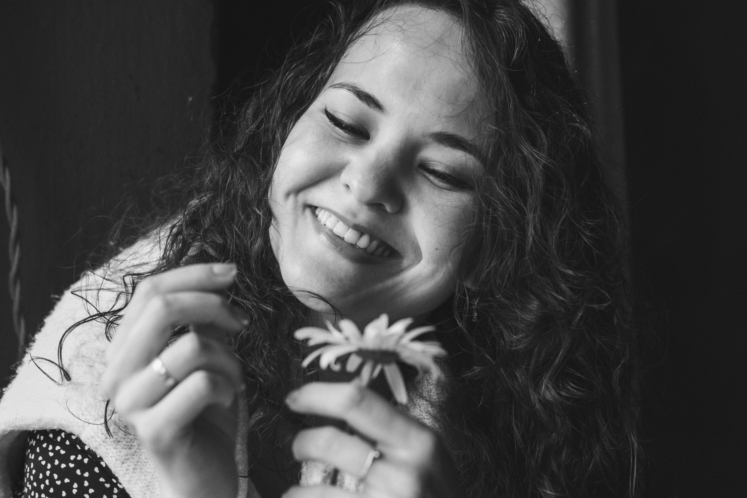 ЧБ портрет красивой девушки с вьющимися  волосами, гадающей на ромашке . фотограф Тюмень