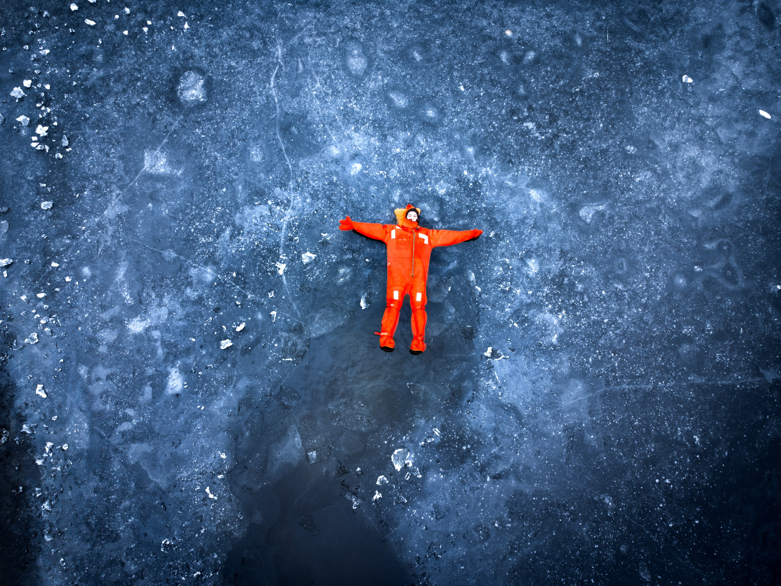 Люди купаются среди льдин, в спасательных оранжевых термо костюмах, айс флоатинг Ярославль