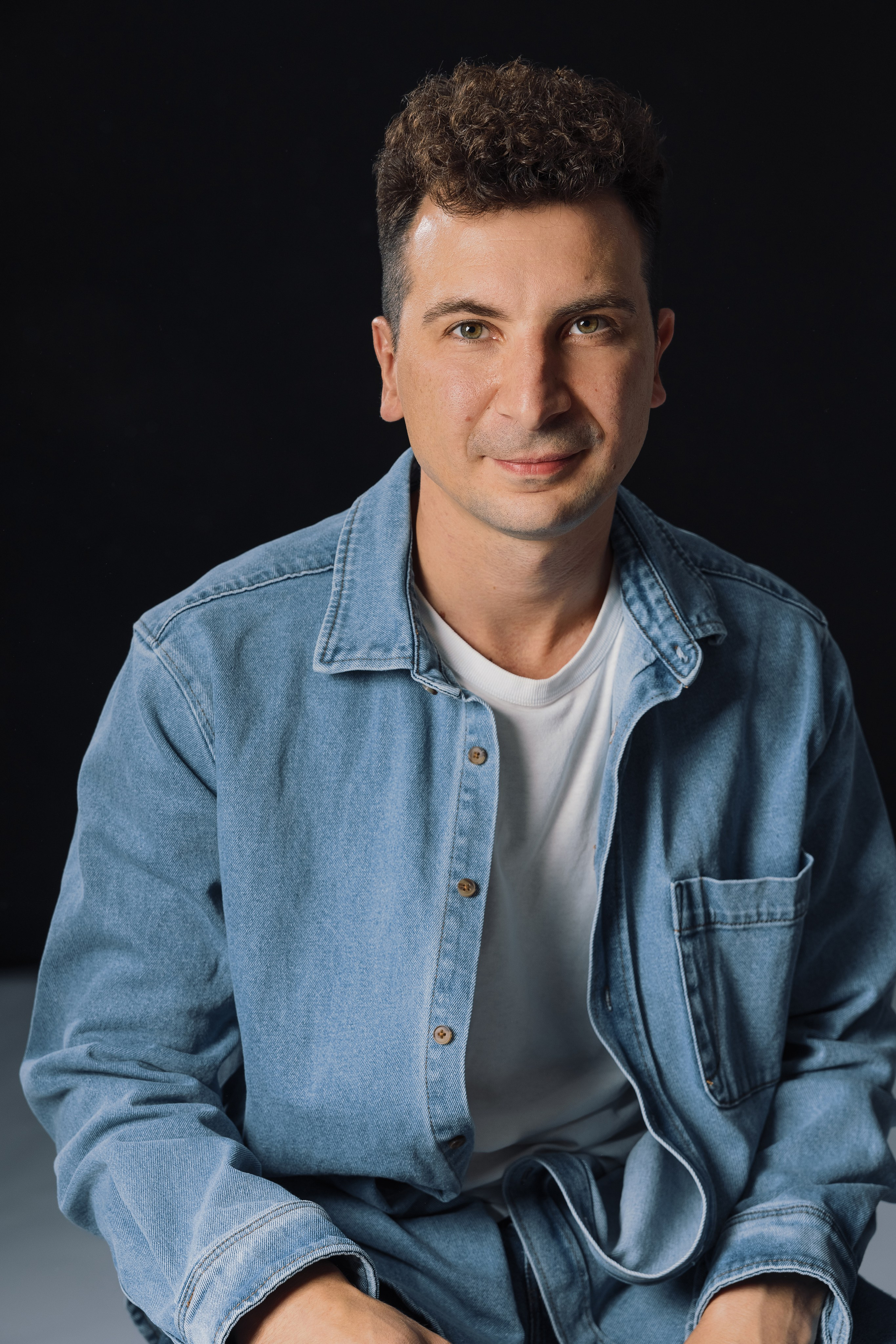 Портрет мужчины в джинсовой рубашке на темном фоне