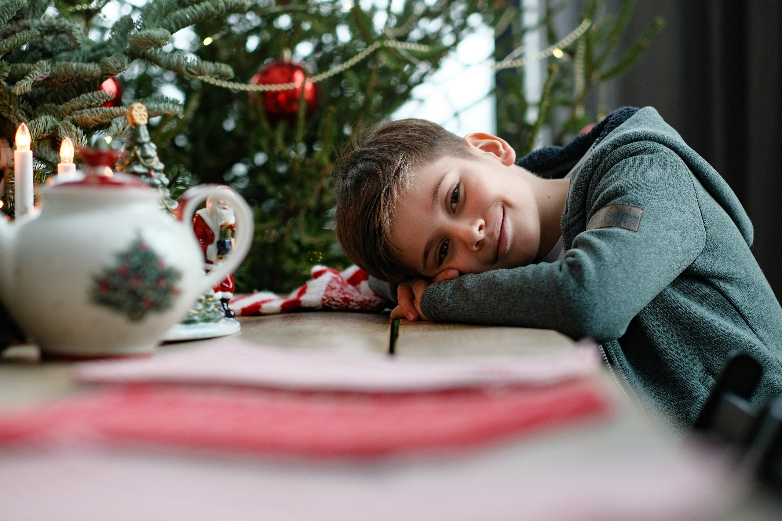 Мальчик лежит на сложенных под голову руках.