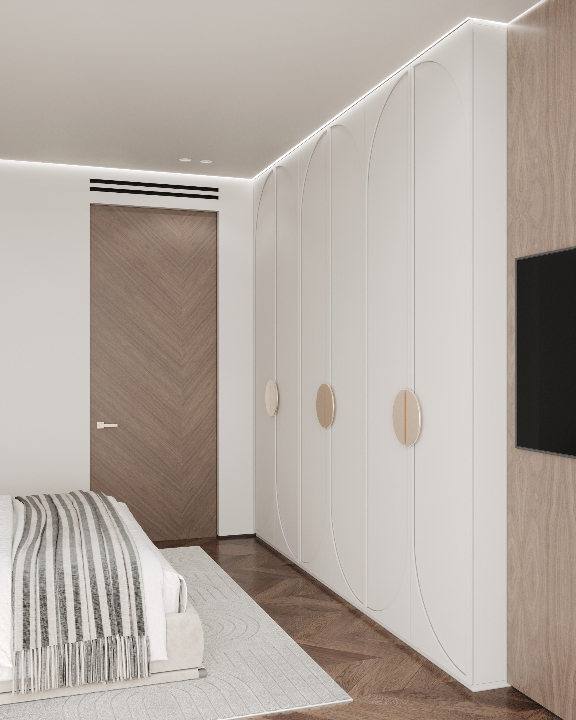 Современная спальня с встроенными белыми шкафами, деревянной дверью с рисунком ёлочкой