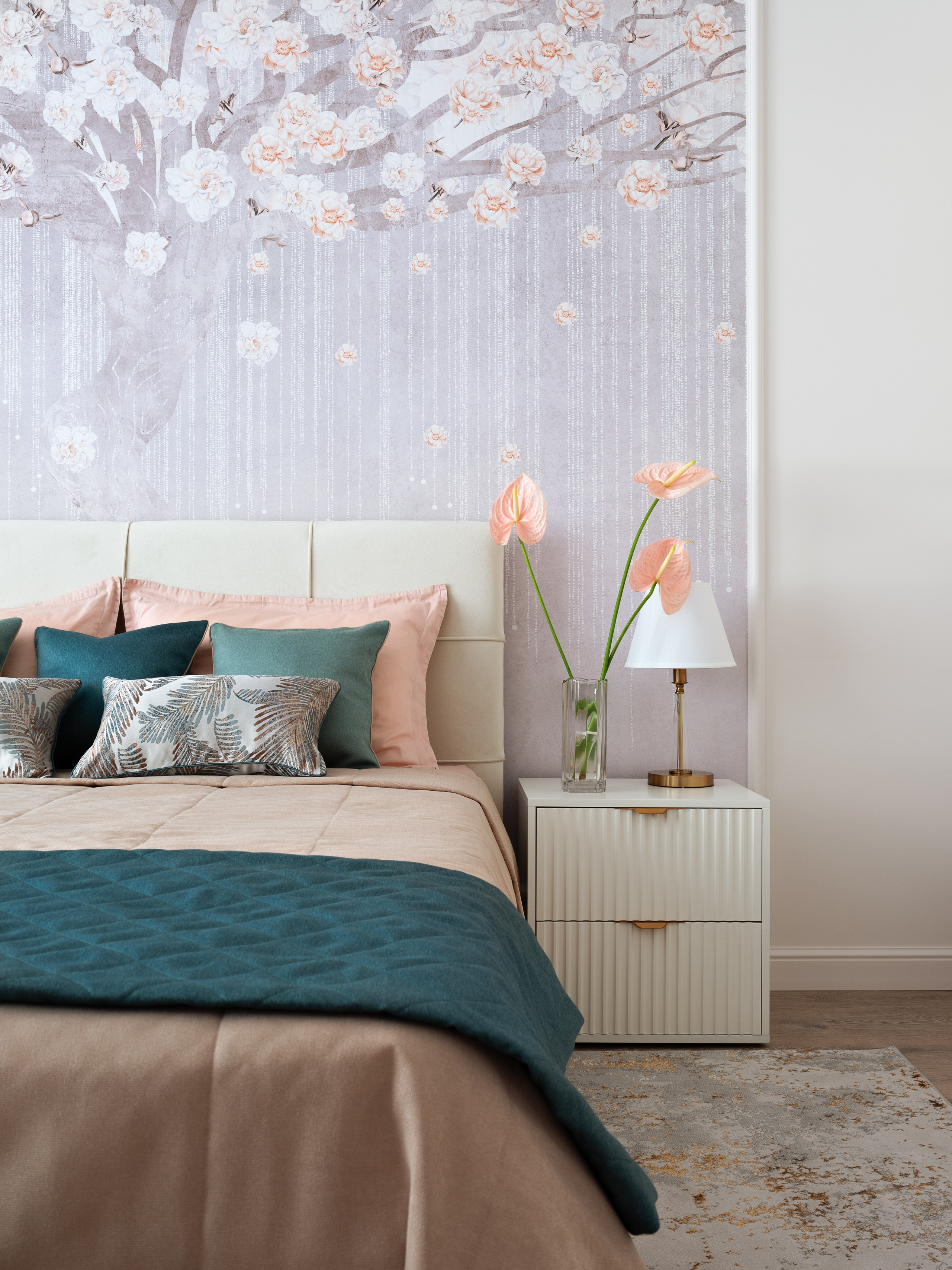 Элегантный интерьер спальни с акцентной стеной в виде нежных обоев с цветущим деревом, мягким изголовьем кровати и декоративными подушками в бирюзово-бежевой гамме. Атмосферный проект создан дизайнером Натальей Бунеевой, стилистикой занималась Наталья Якушева, а автор фото — Сергей Денисенко.