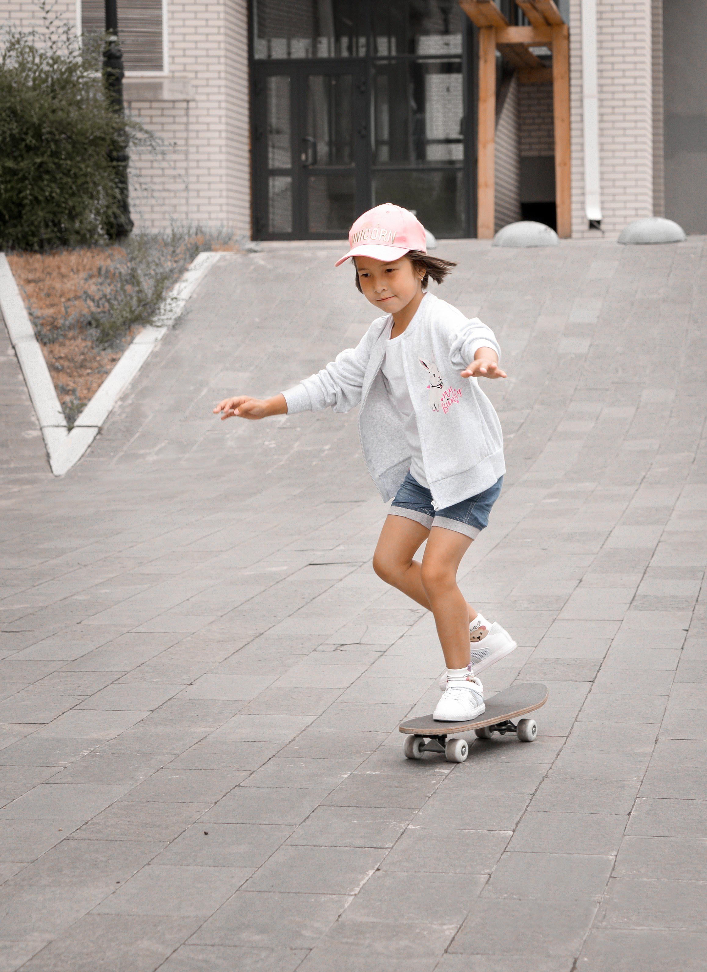 Детская фотосессия летом - девочка в бейсболке на скейте