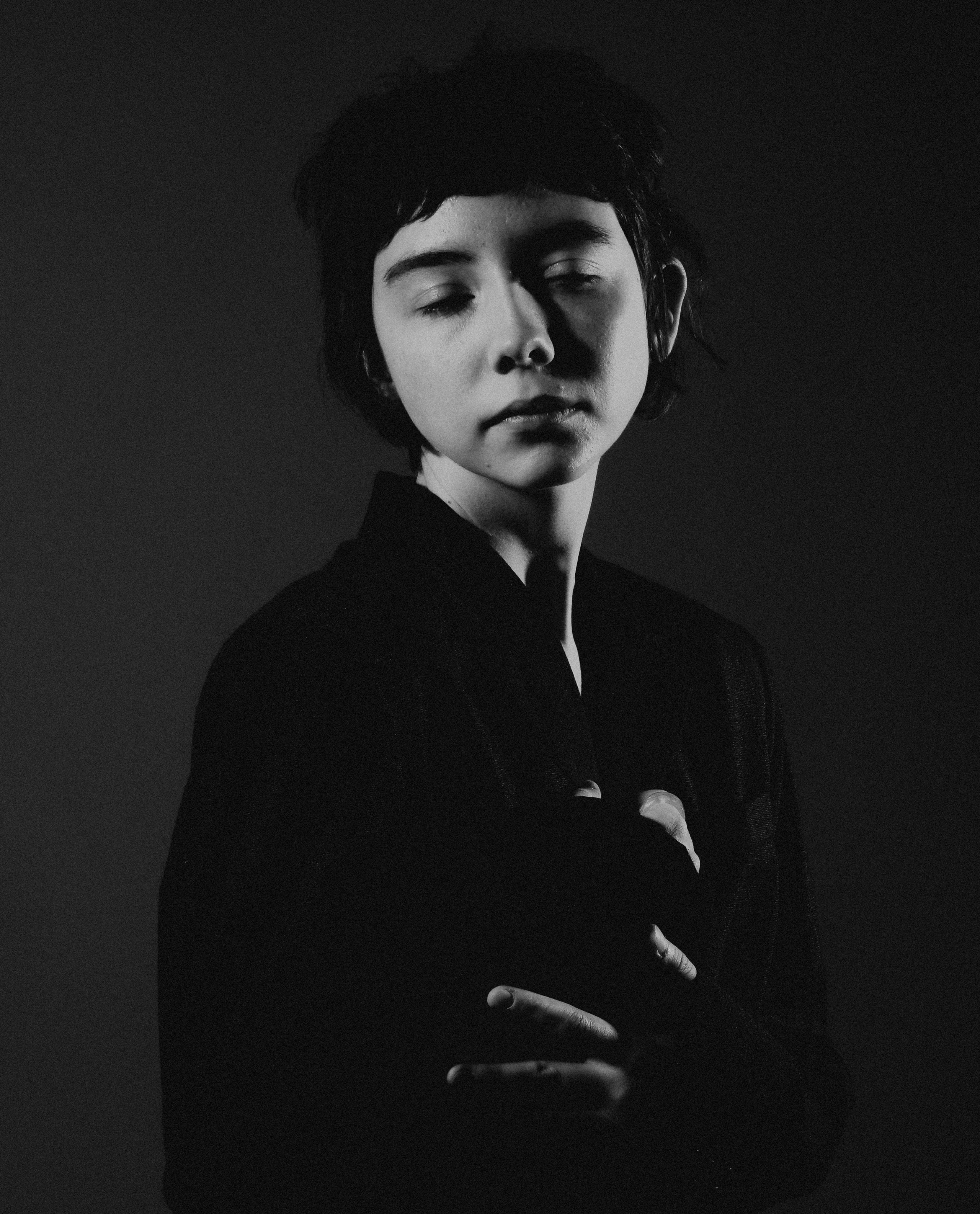 Модель в чёрном пиджаке обнимает себя