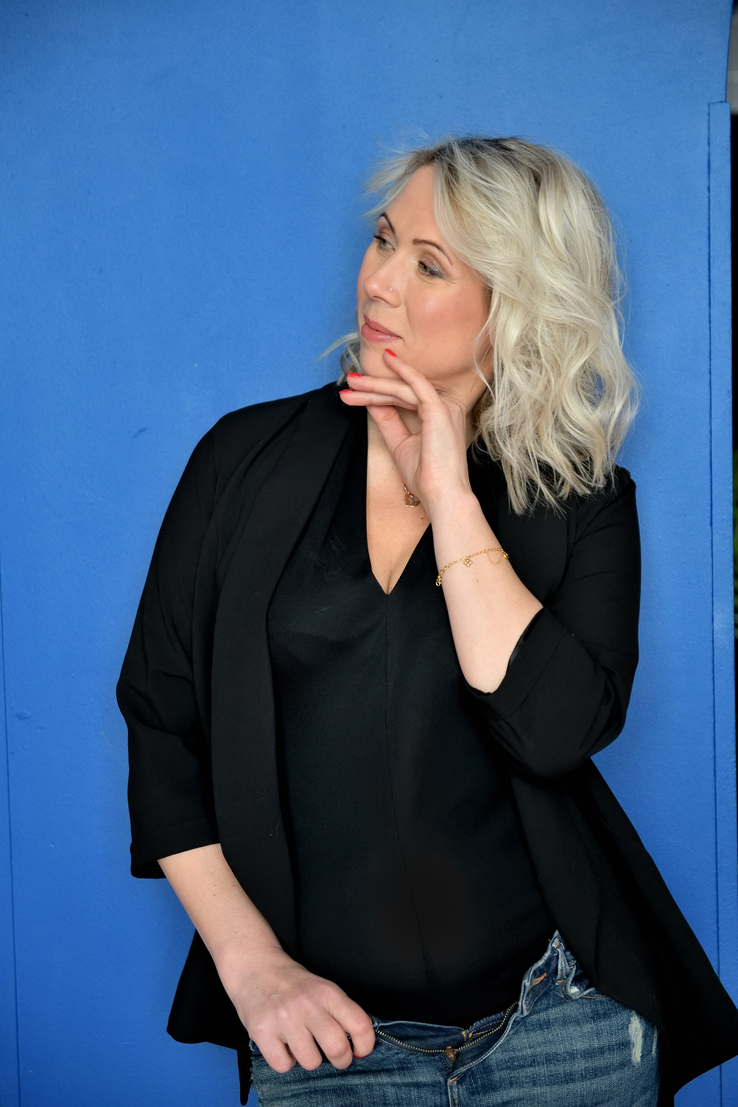 Портрет красивой женщины на фоне голубой стены.